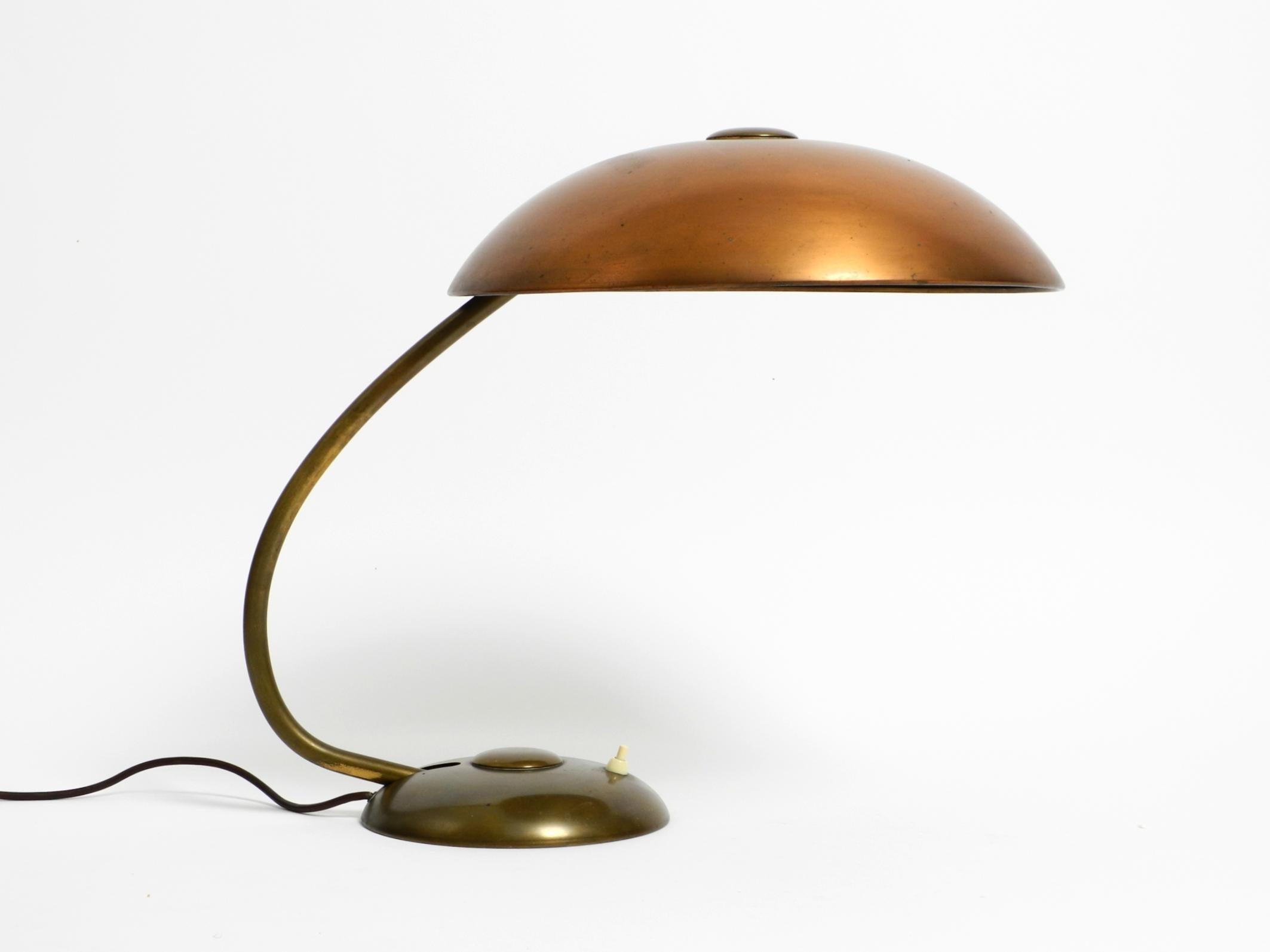 Très grande et lourde lampe de table moderne du milieu du siècle dernier. Fabriqué en Allemagne.
Fabriqué au début des années 1950. Très solide et conçu pour durer.
La base et le col sont en laiton. Le grand abat-jour d'un diamètre de 40 cm est en