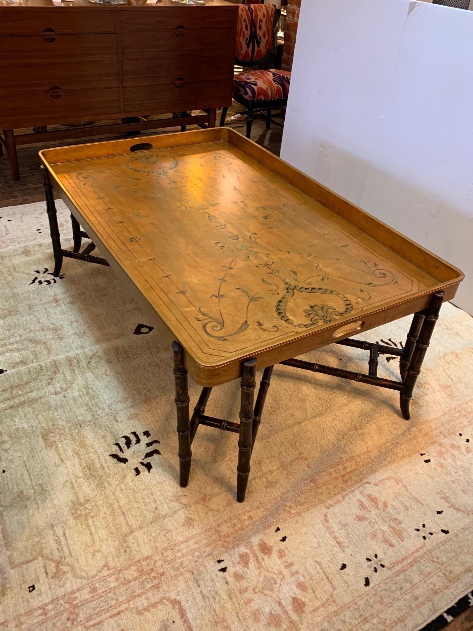 A very large glamorous tray style coffee table having gilded and hand painted top with handles and a stunning ebonized faux bamboo base. 2.5