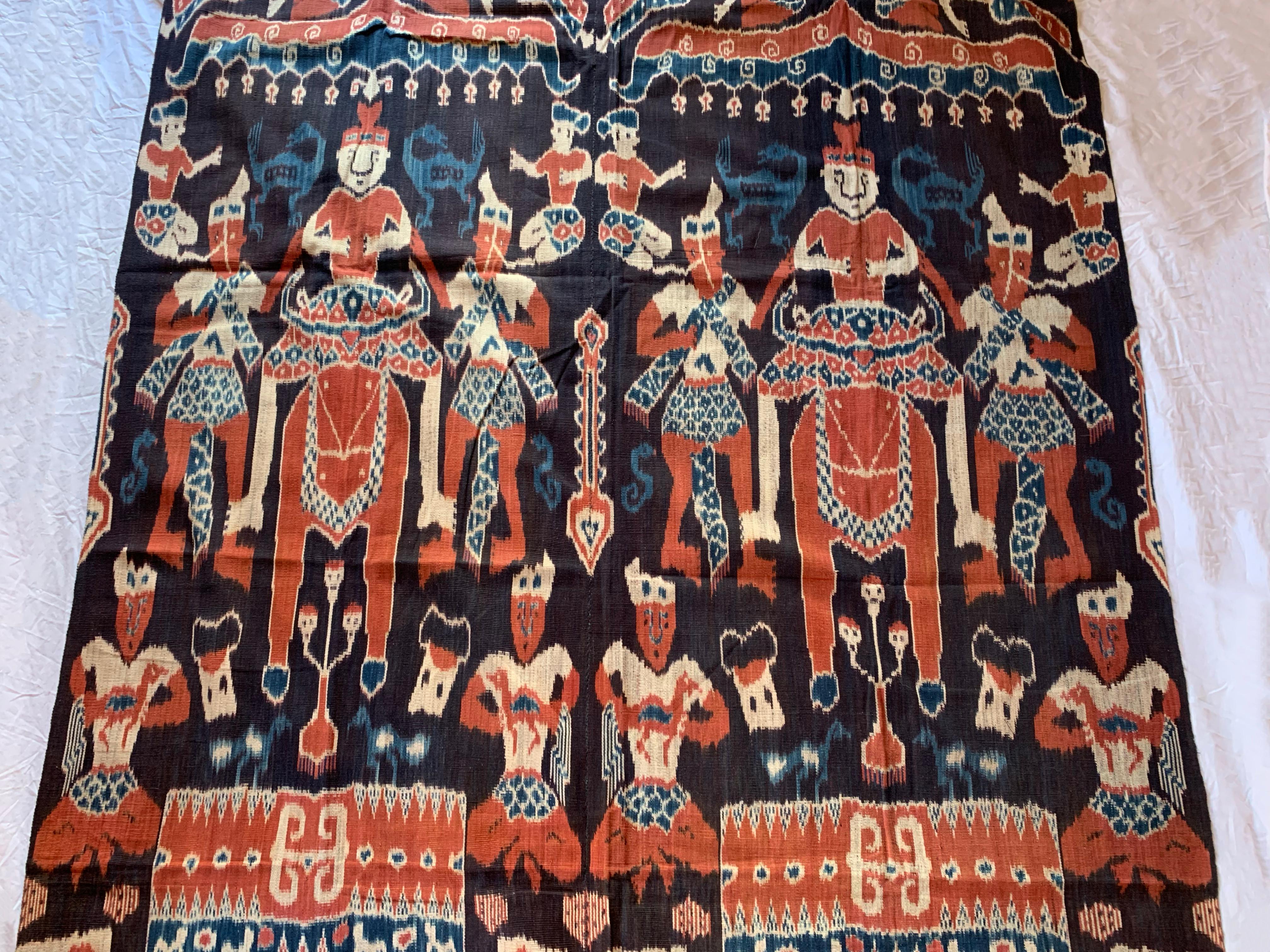 Dieses Ikat-Textil stammt von der Insel Sumba in Indonesien. Es wird mit natürlich gefärbten Garnen nach einer seit Generationen überlieferten Methode handgewebt. Es zeigt eine atemberaubende Vielfalt an unterschiedlichen Stammesmustern und Motiven