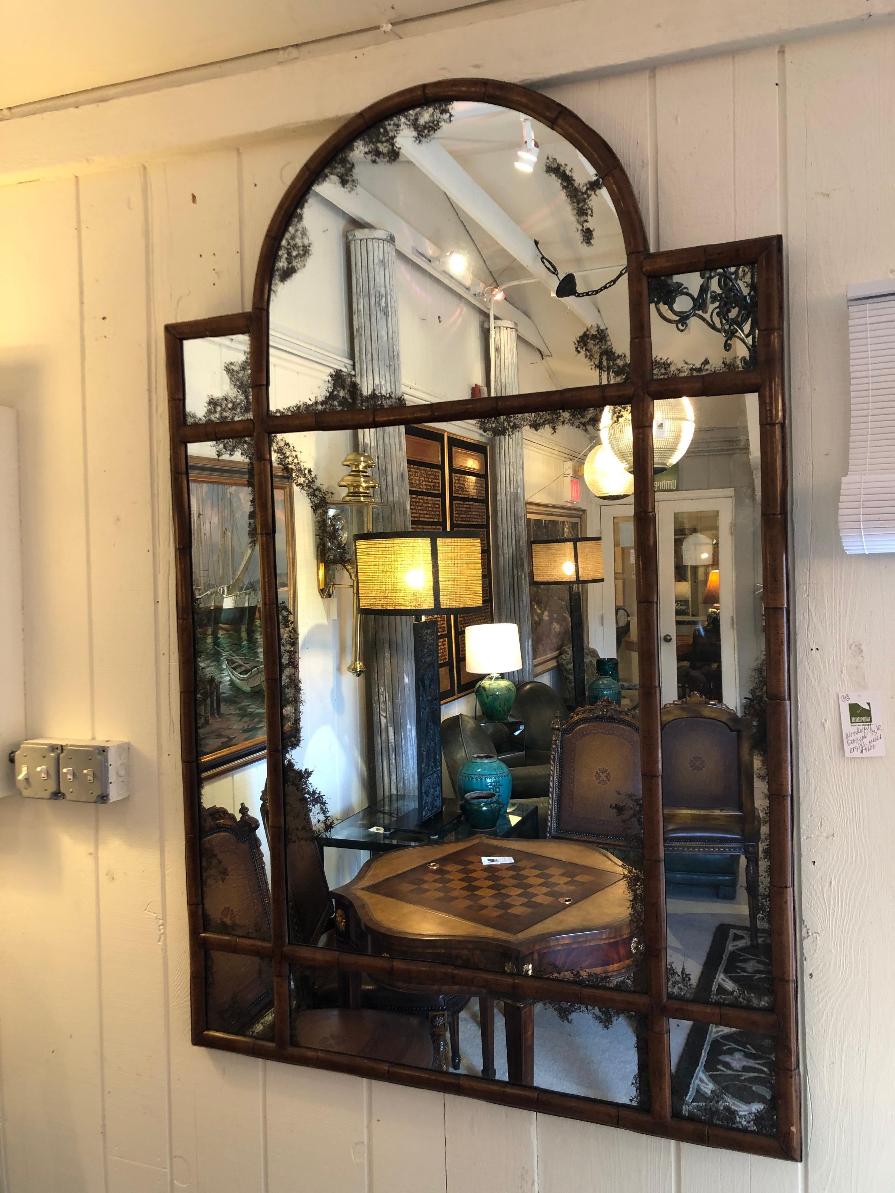 A large beautifully shaped arch topped mirror having walnut faux bamboo frame and handsome ghosted mirror.