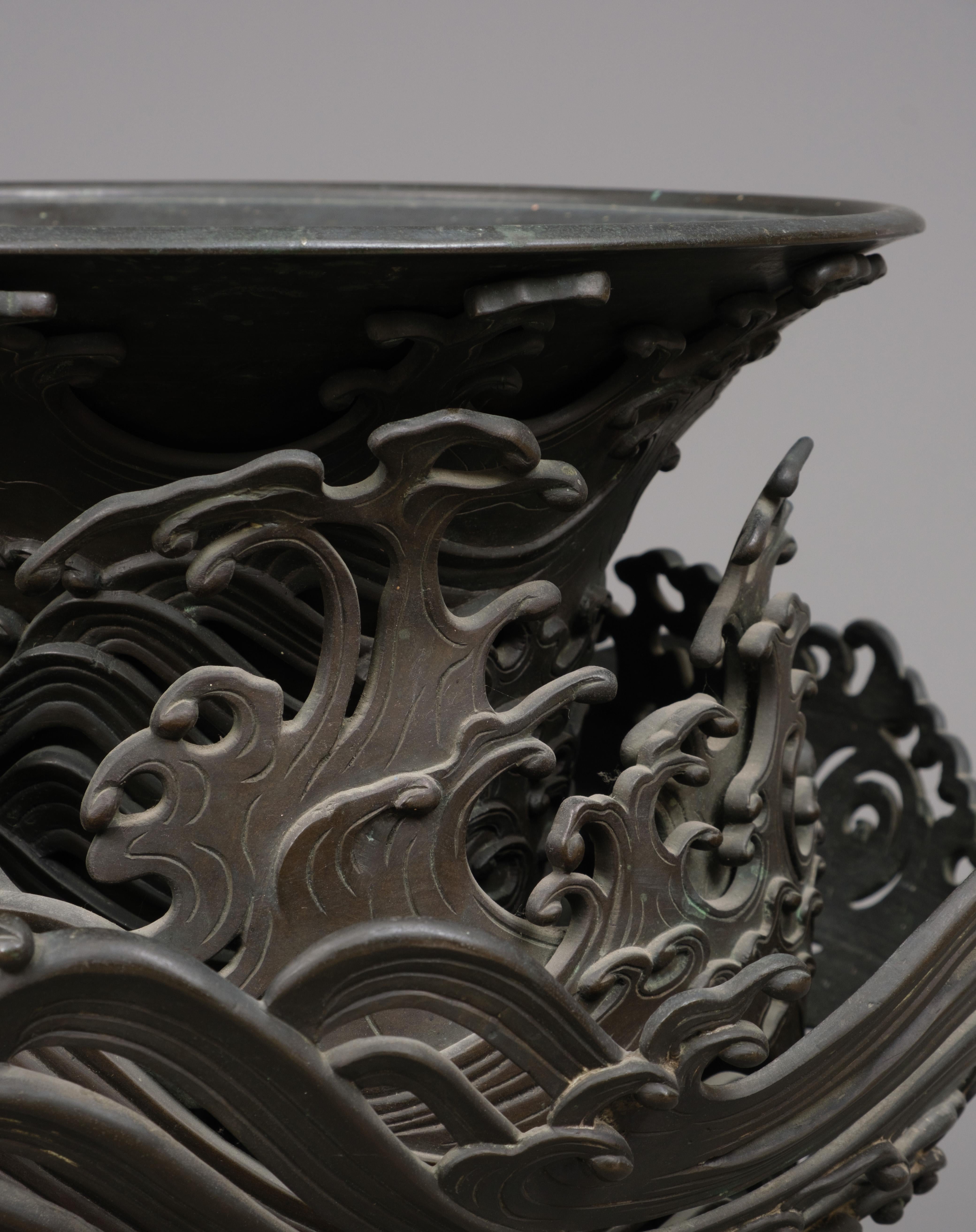 Cast Very large Japanese bronze 4-tiered trumpet vase with intricate wave design For Sale