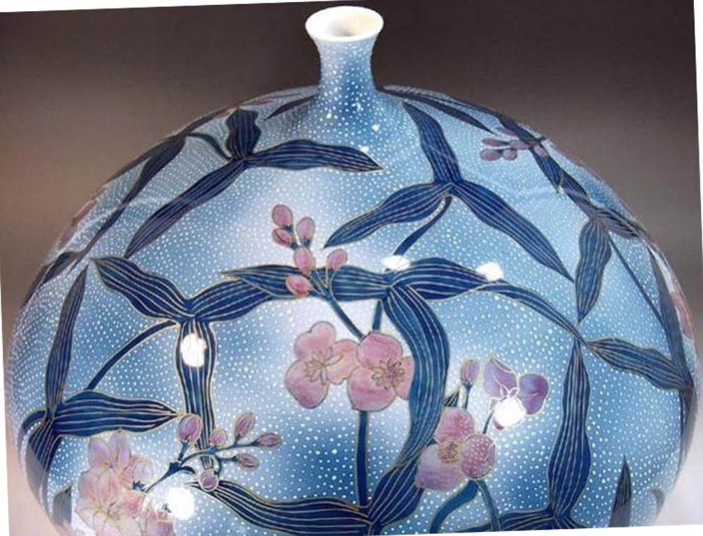 Exquisite zeitgenössische japanische Vase aus vergoldetem Porzellan, aufwändig handbemalt in Blau- und Rosatönen auf einem wunderschön geformten Korpus, ein auffallend signiertes Werk eines hochgelobten Meisters aus der Region Arita-Imari in Japan.