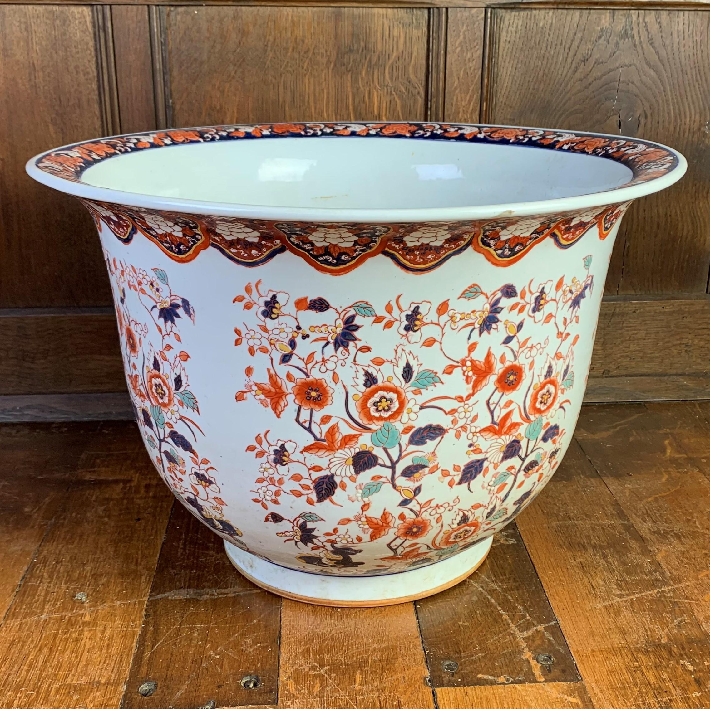 A very large Japanese porcelain plant-pot painted in typical Imari colours with flowers and foliage. This impressive 20th century bowl is undamaged and unrestored and would make a staunning container for a large indoor plant or tree.