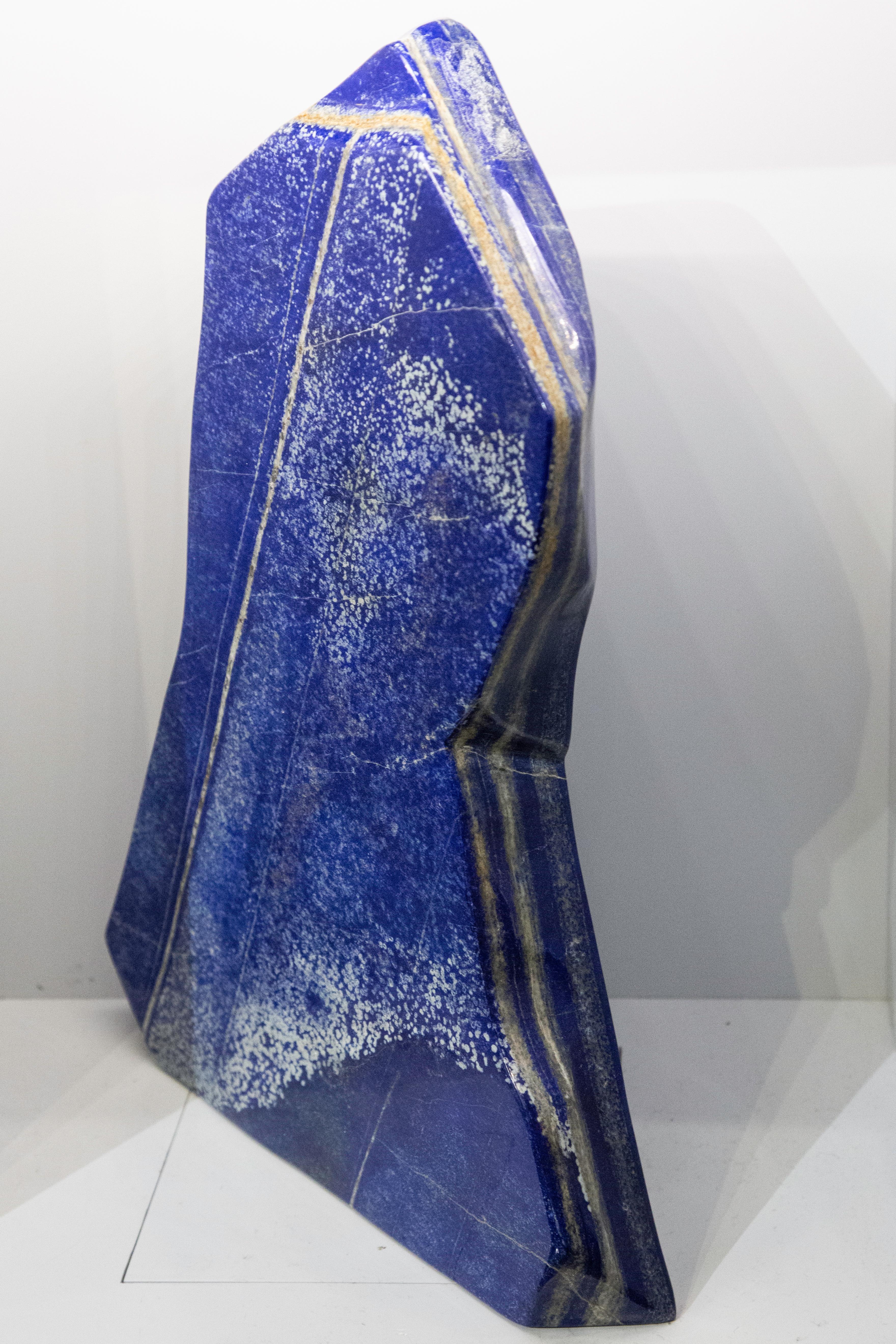 Very large polished lapis lazuli mineral specimen from Afghanistan, free standing and weighing 42 lbs. This semi-precious stone has been prized since antiquity due to its intense, beautiful blue coloring and golden speckles. It was also used in the