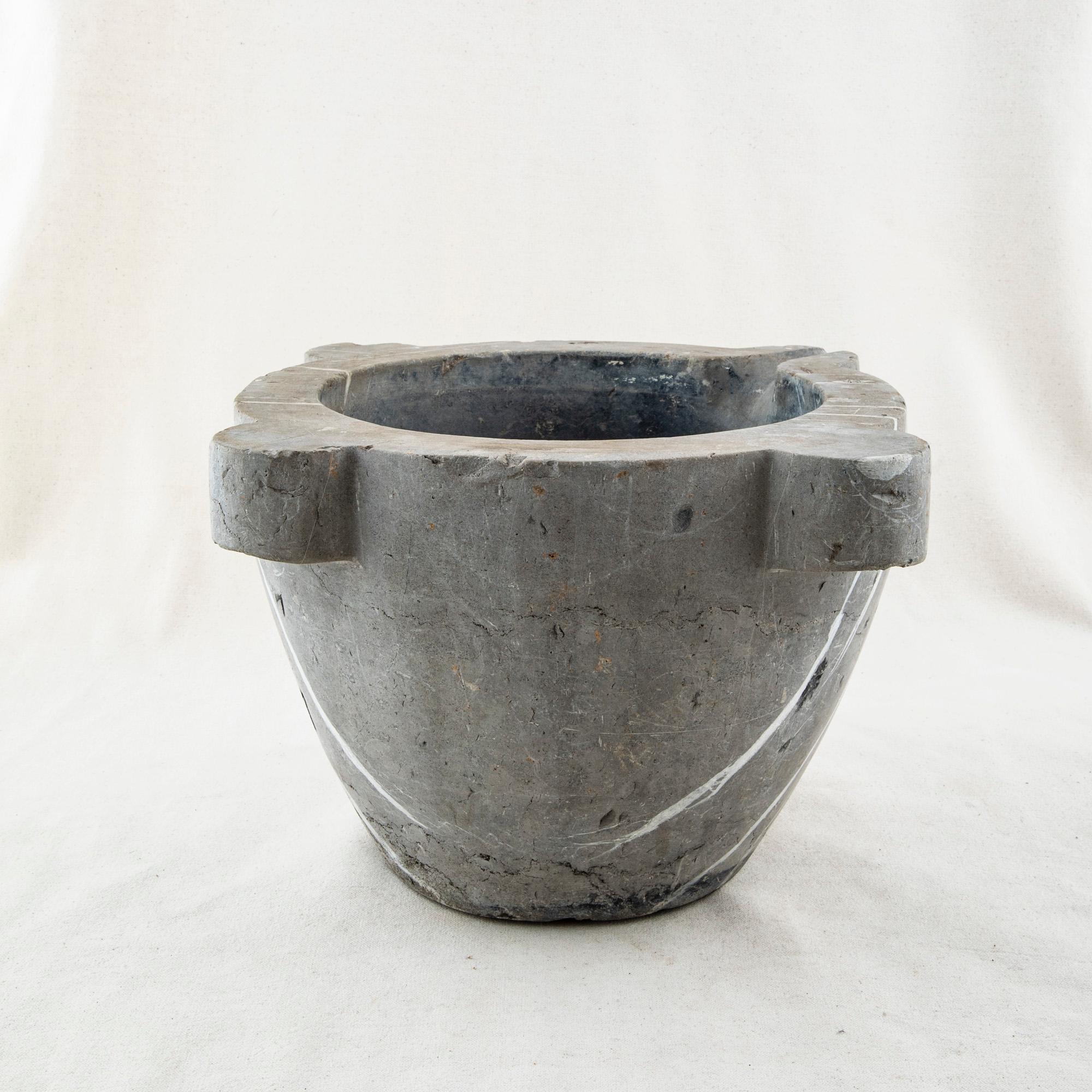 This exceptionally large late nineteenth century marble mortar is made from a single block of grey marble with white veining. Once used with its accompanying pestle by a pharmacist to grind herbs for medicinal purposes, it can now serve as a