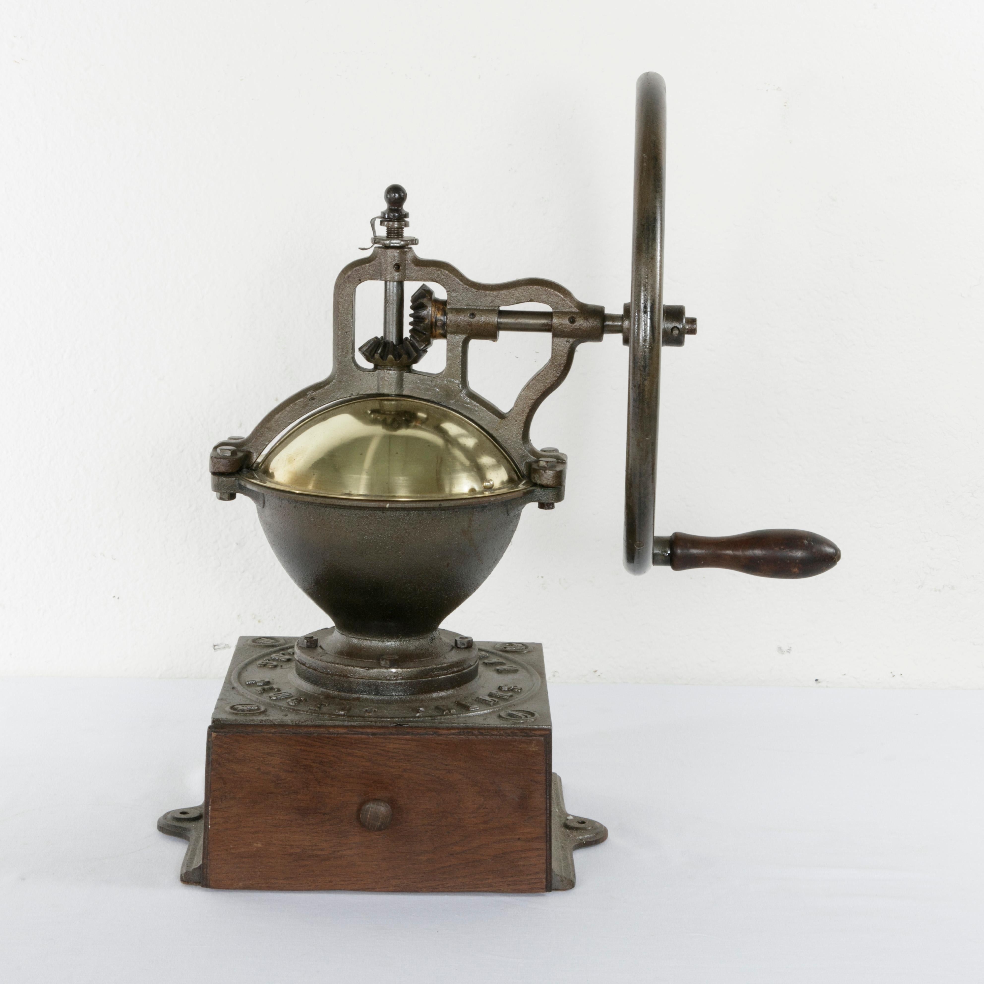 This very large late 19th century iron coffee grinder was originally used in a French bistro. Marked Peugeot Freres Brevetes SGDG, and the number 4, this coffee grinder was the second largest in size ever produced by Peugeot Freres. Its brass cover