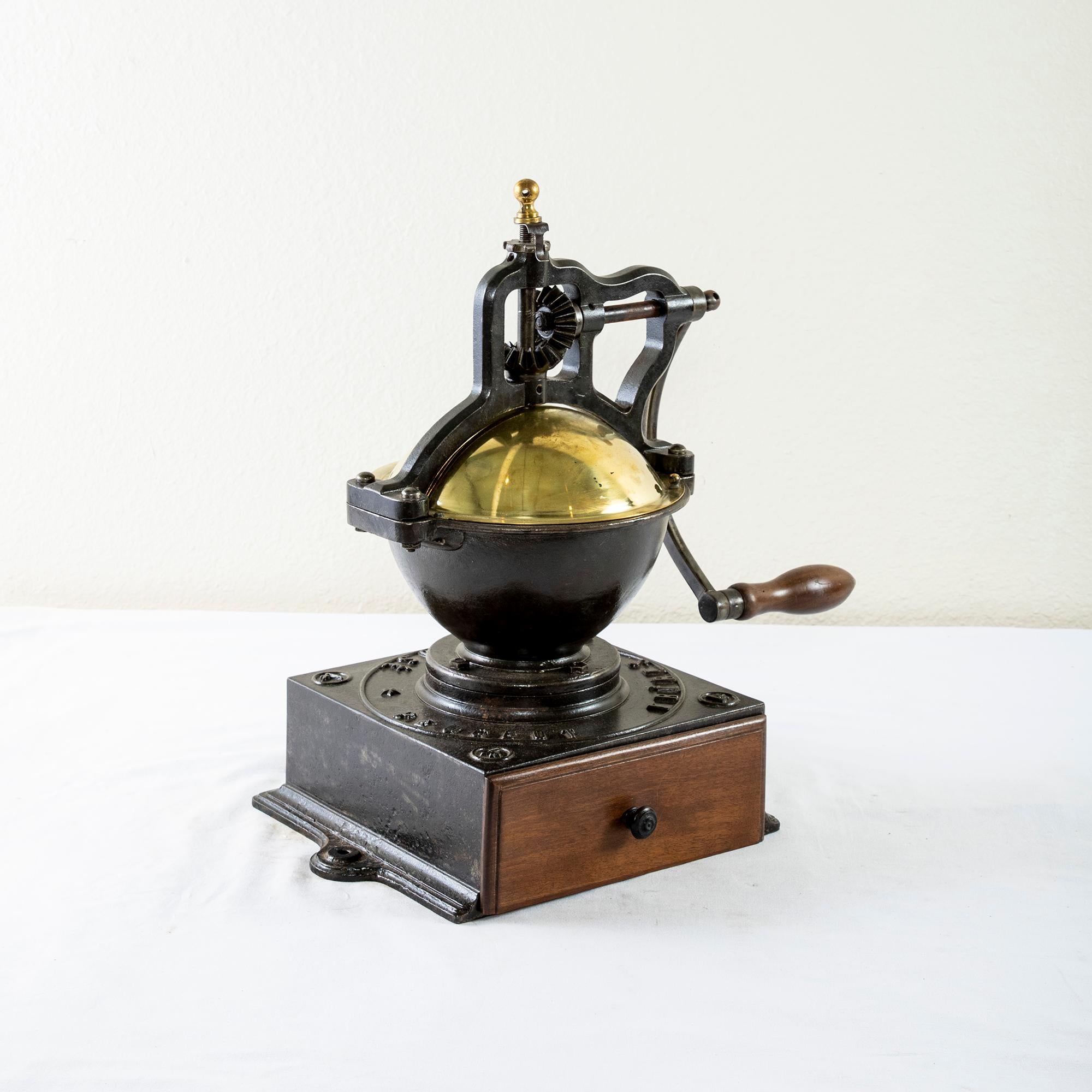 This very large late 19th century iron coffee grinder was originally used in a French bistro. Marked Peugeot Freres Brevetes SGDG, and the number 4, this coffee grinder was the second largest in size ever produced by Peugeot Freres. Its brass cover