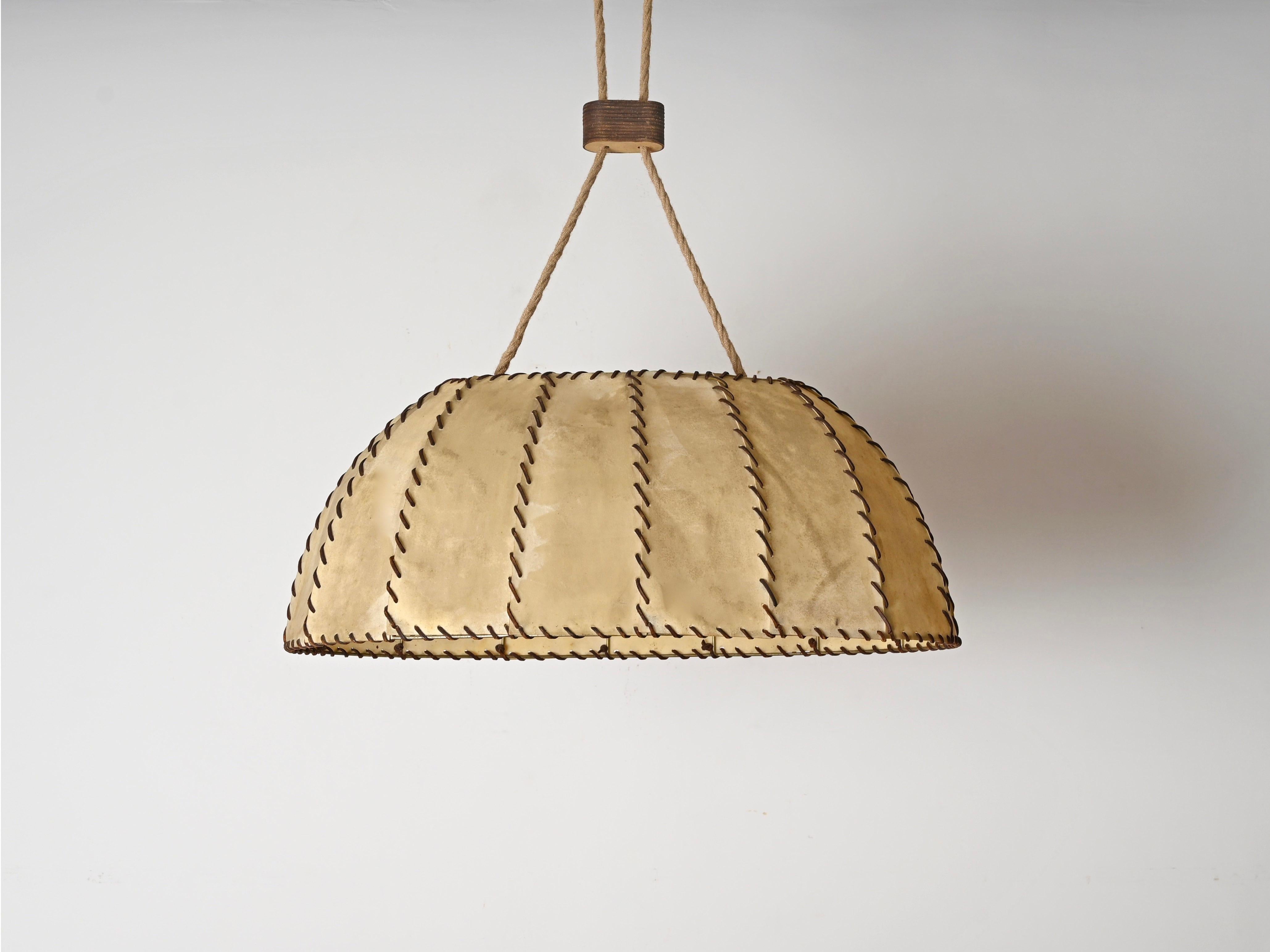 Majestic and unique large chandelier made in a charming combination of leather and vellum with a rope cord. This fantastic piece was produced in Italy during the 1940s and its design is attributed to the mastery of Max Ingrand.

Fully original and