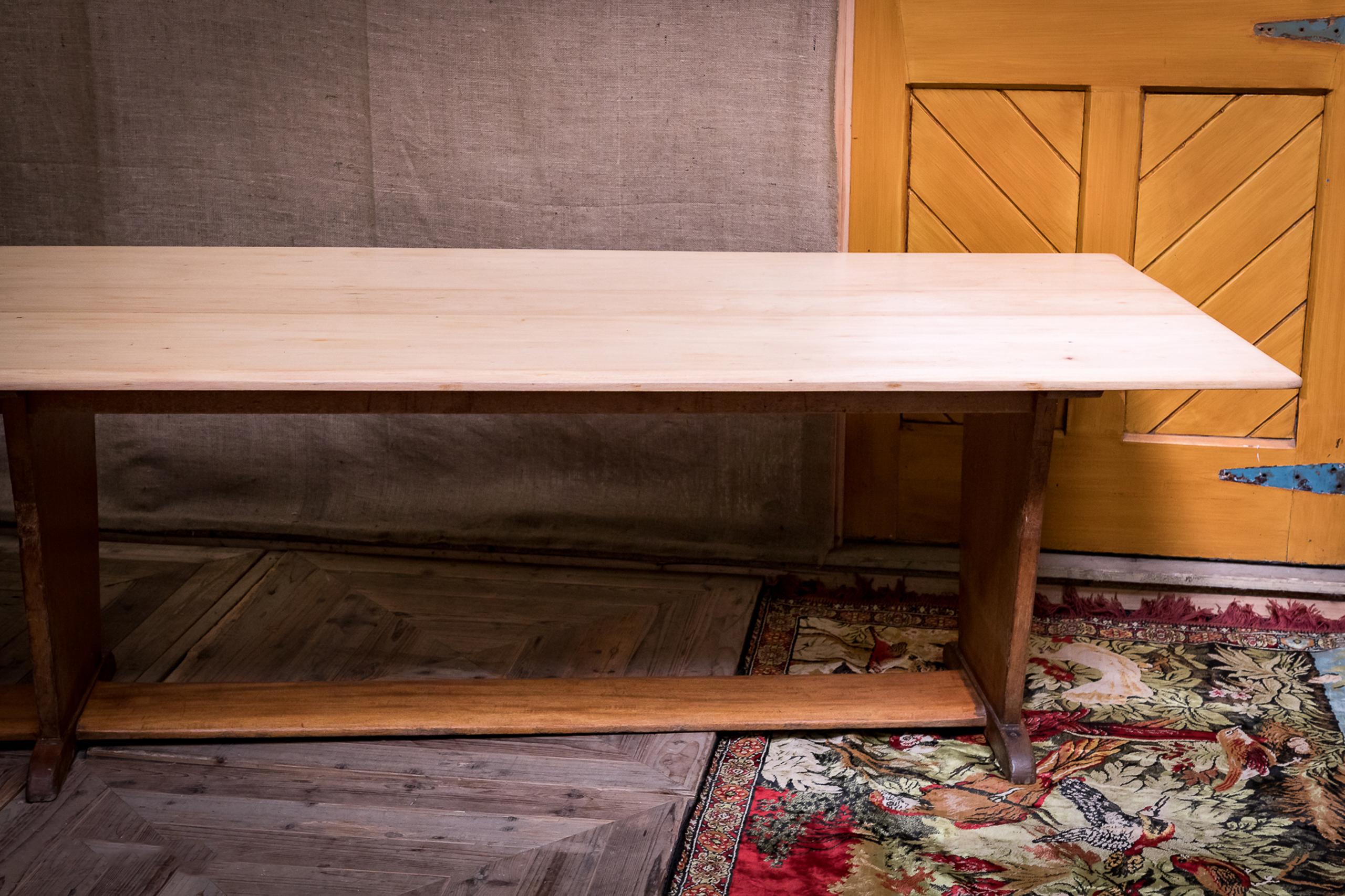 A huge midcentury beech dining or board room table of typical midcentury design raised on solid panel legs above a full length stretcher panel base. The tabletop has recently been stripped and is a lovely light beech where as the base retains the