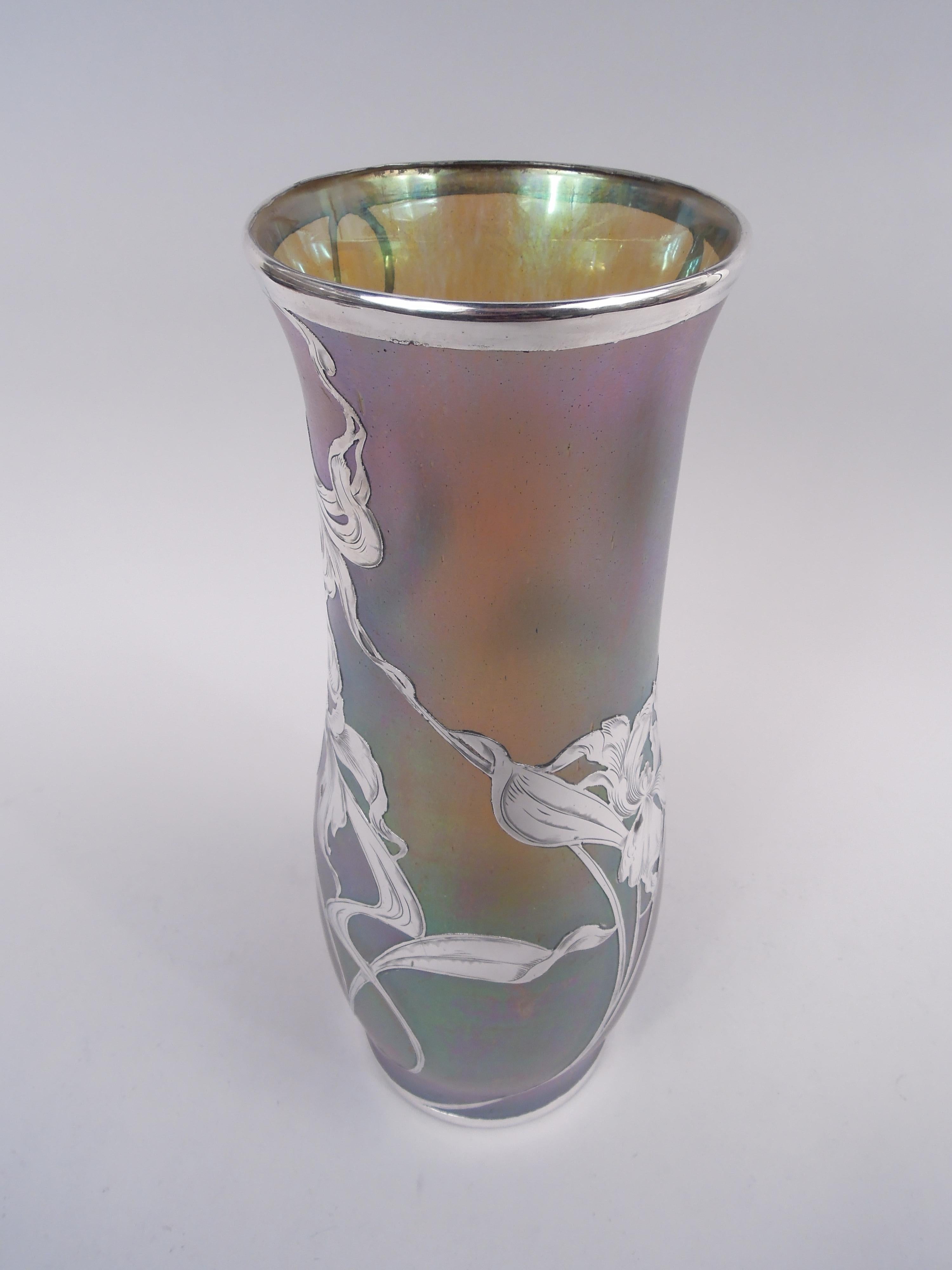 Vaso in vetro artistico molto grande di fine secolo realizzato dallo storico Glass Glass. Delicata balaustra in blu iridescente che sfuma verso l'oro. Sovrapposizione di argento inciso a forma di iris giapponesi. Grandi fiori e viticci a frusta. Un