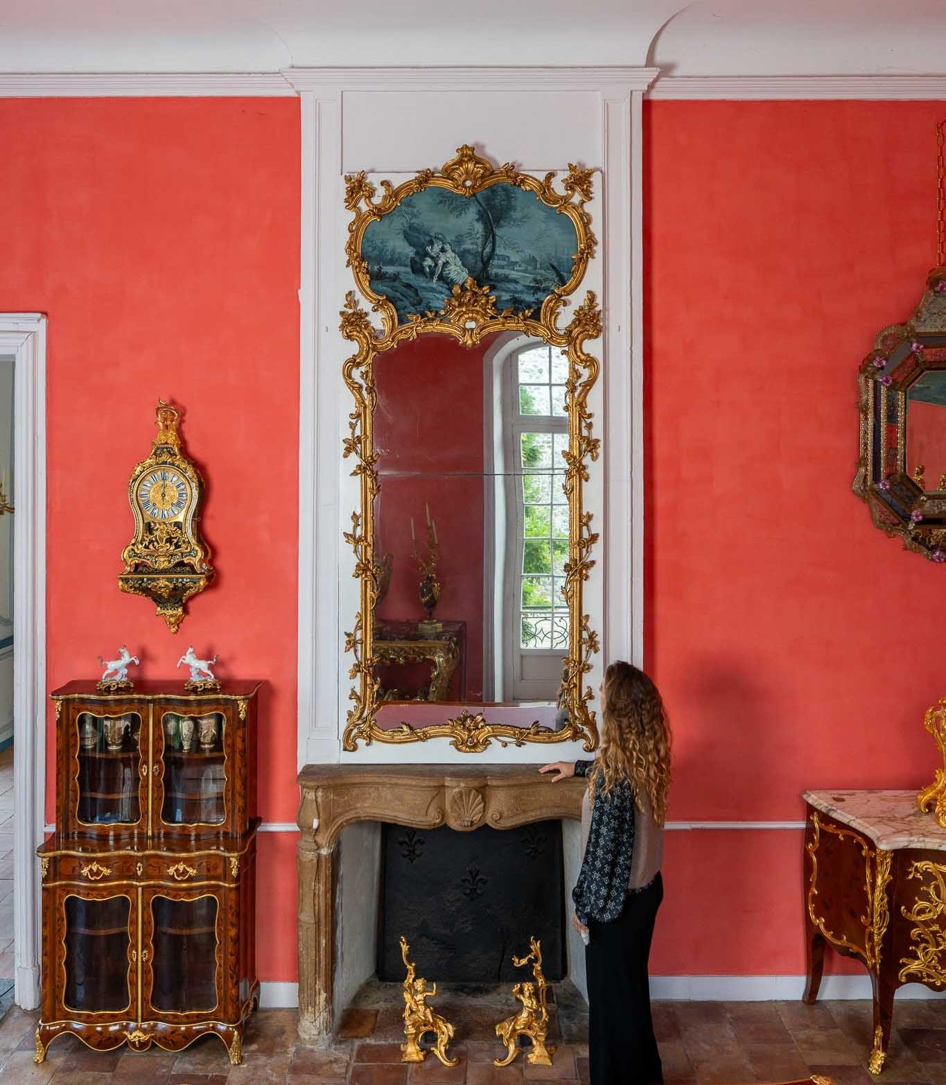 Ce miroir Louis XV est une pièce exceptionnelle qui incarne toute la richesse et l'élégance du style Rocaille du XVIIIe siècle. Son somptueux cadre en bois doré présente des motifs sculptés de feuilles, de fleurs et de volutes, typiques de