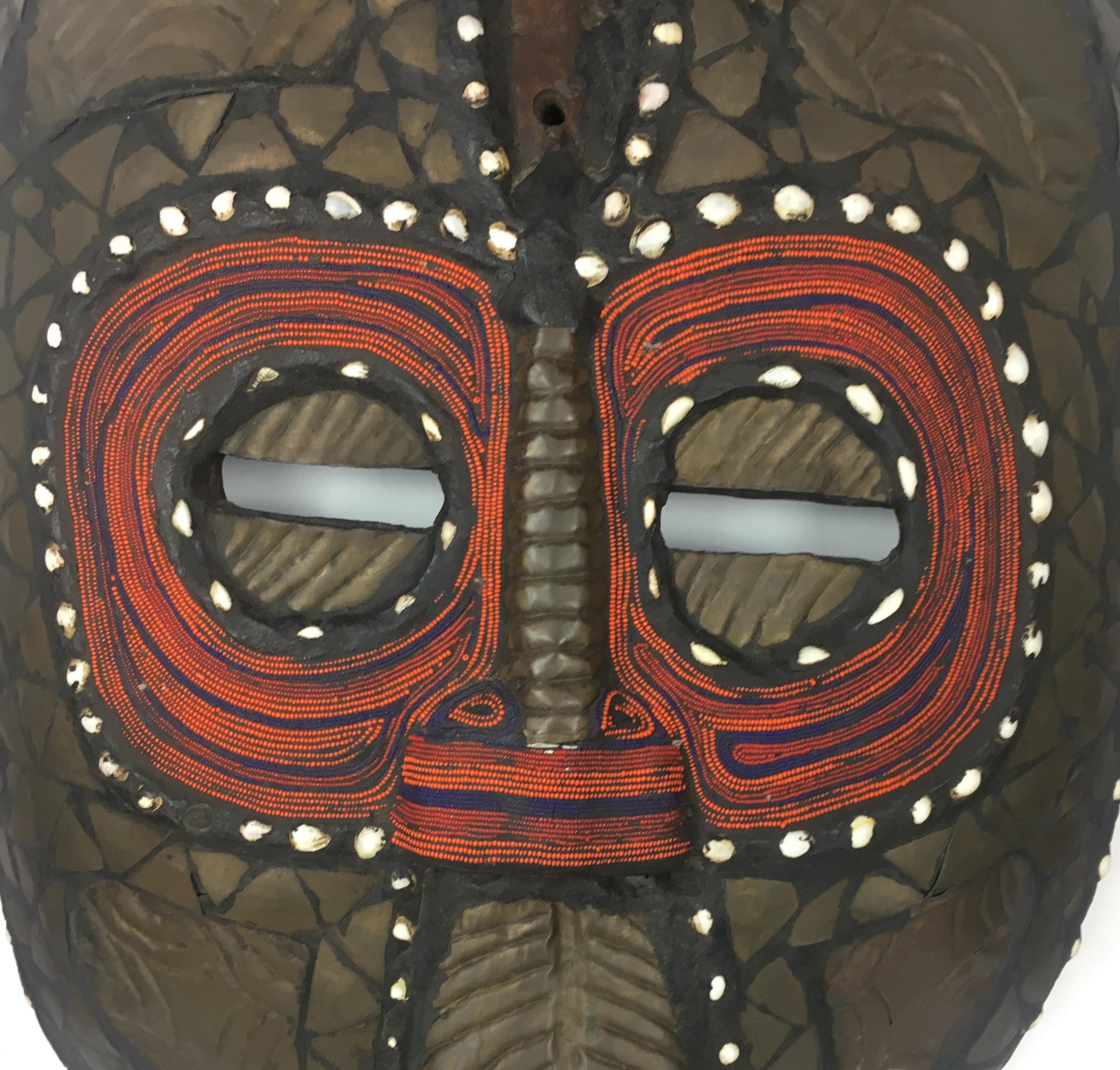 Magnificent African tribal mask hand-carved and constructed with copper and wood. Decorated with elaborate shells, and colorful tribal designs. Very Large and heavy. 

Exact origins are unknown, however, this large decorative piece resembles