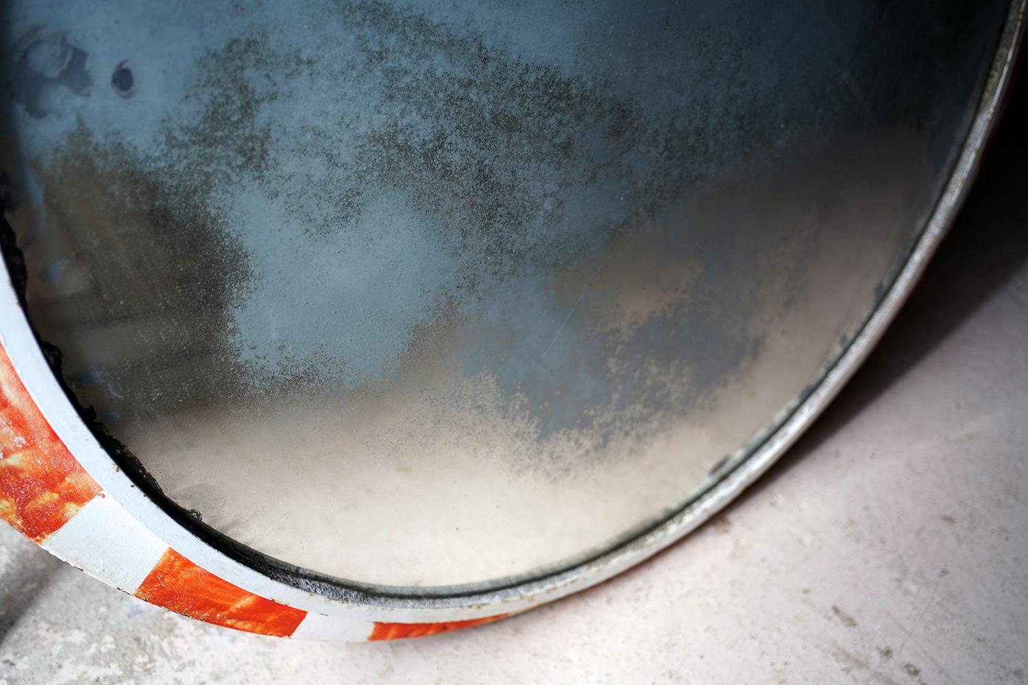 The large and very decorative circular railway or tram system mirror, nearing five feet in diameter, having an elliptical iron frame extending below the mirror edge, with wonderfully aged original glass, foxed and worn, to a red and white painted
