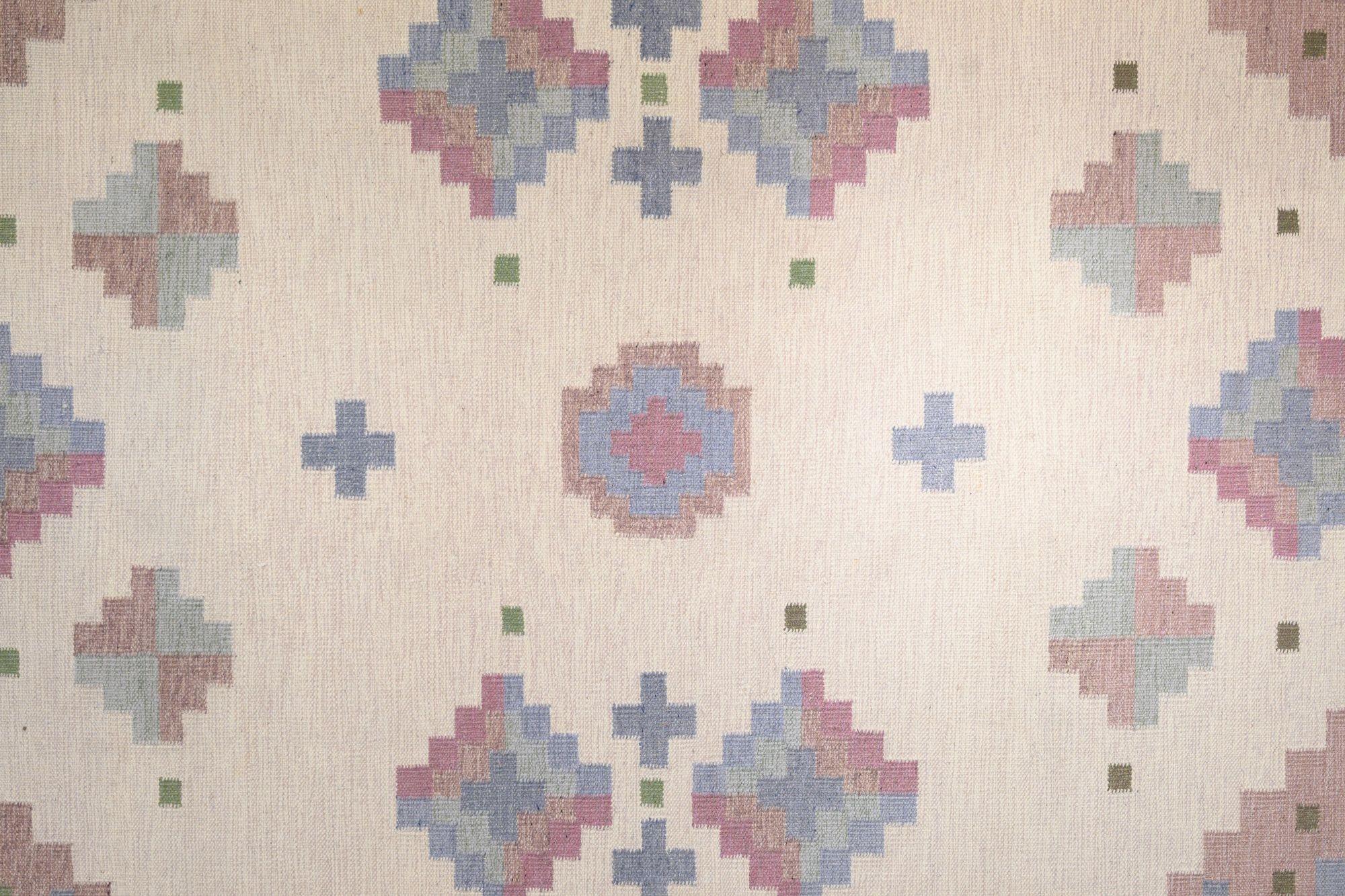 Very large mid-century Swedish kilim in tones of pink and a cream base, geometric design with hints of blues and green. Professionally cleaned. Sweden circa 1960.