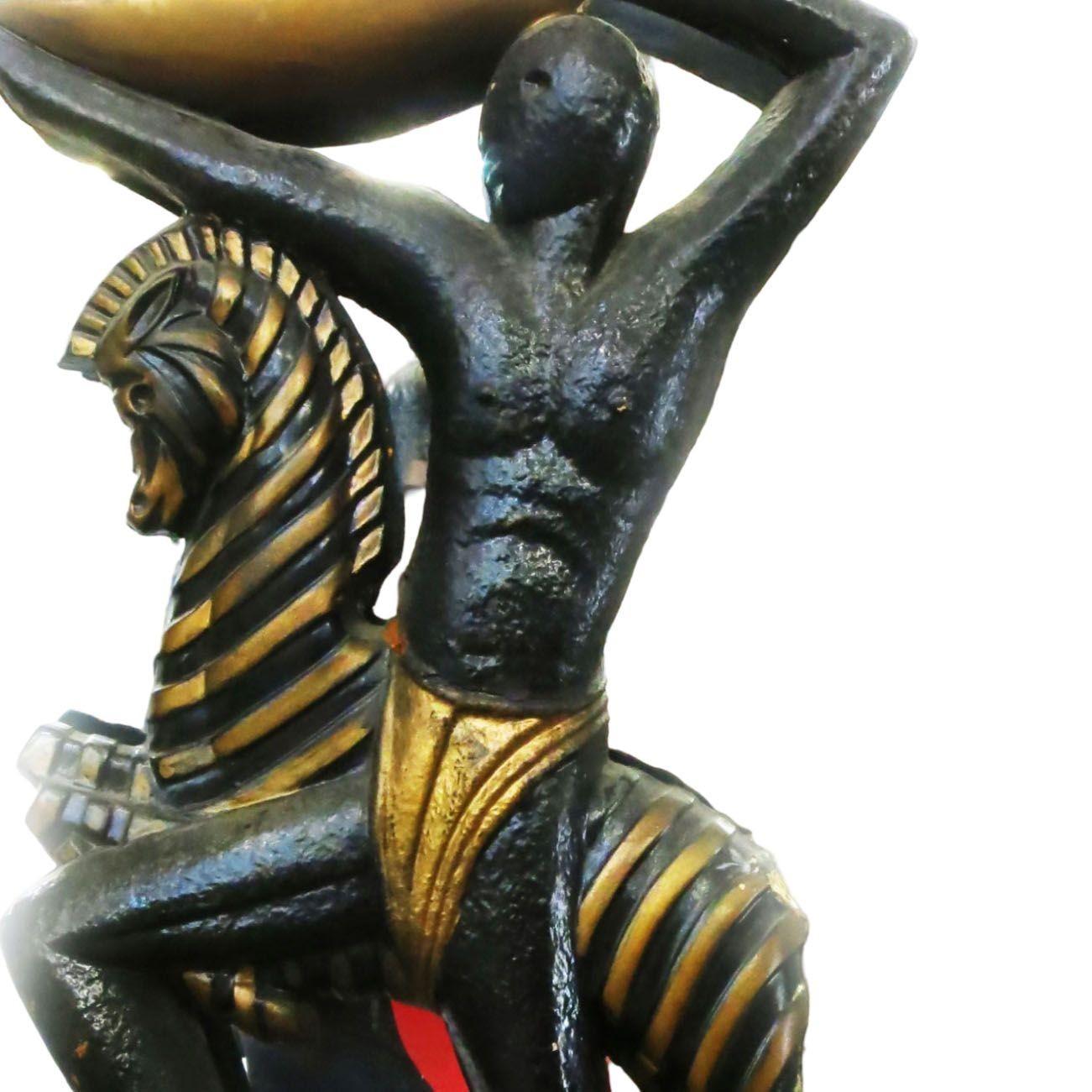 El espejo de pared original de mediados de siglo con esculturas tribales masculinas y femeninas talladas está en el centro, rodeado por un espejo de madera peinada. Cada estatua se ha pintado a mano en oro y laca negra, y el marco se ha pintado con