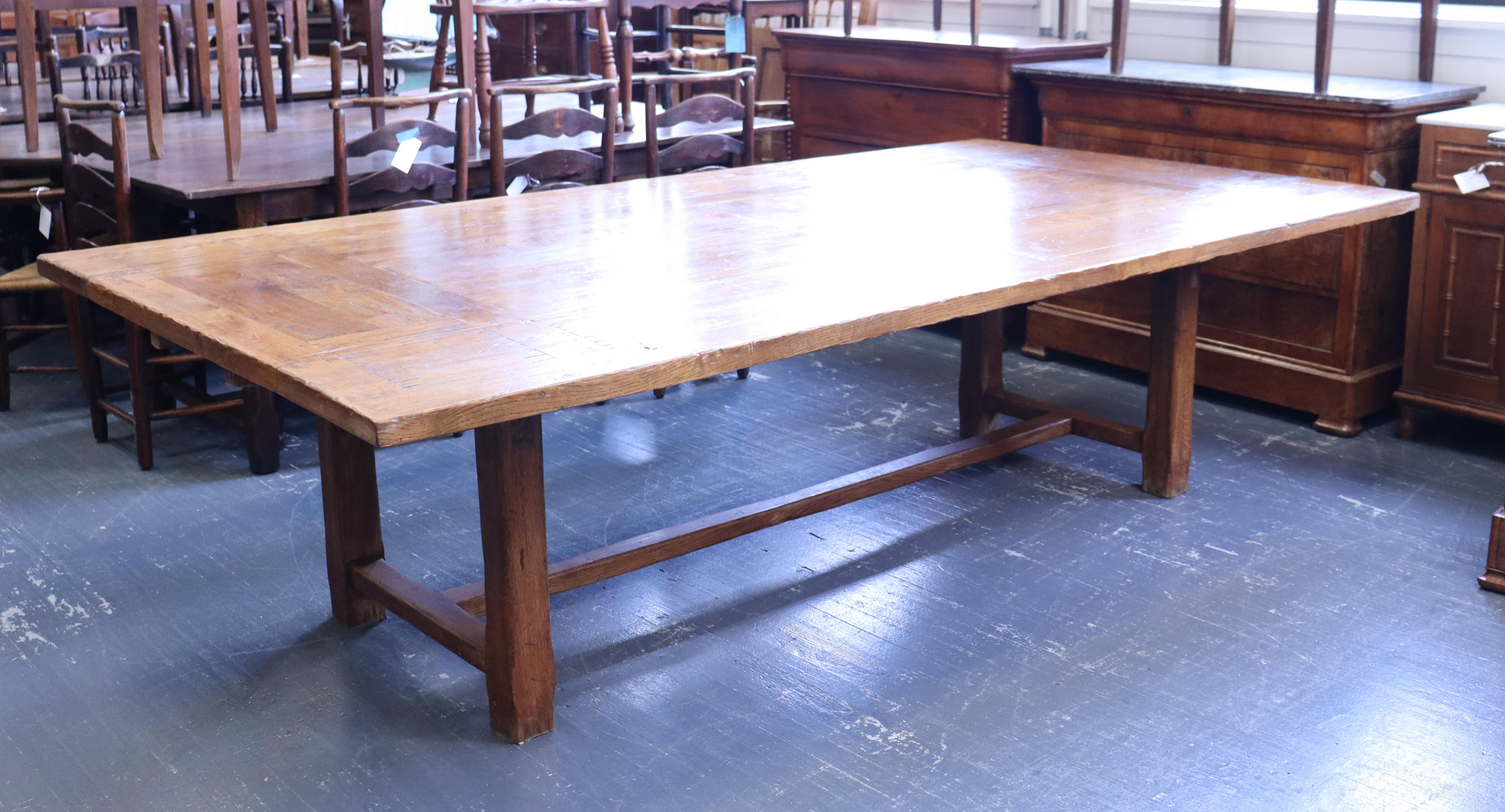 A very large oak dining table of unusually grand proportions.  Made of rich Golden Oak, this table has the capacity to seat 3 at either end and 5 on a side, or 16 total.  2 small drawers nestled in the apron and a sturdy trestle base.  Very good oak