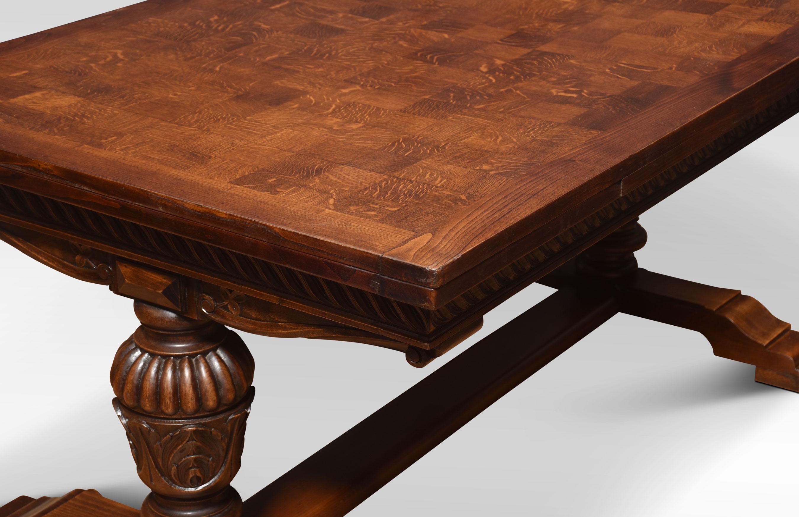 Oak draw-leaf refectory table of generous proportions. The thick parquetry top having pull-out leaves to each end above molded frieze raised on bulbous legs leading down to square feet united by H stretcher. Will seat 10 people