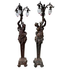 Très grande paire de lampes figuratives en bronze représentant des torchères, vers les années 1920