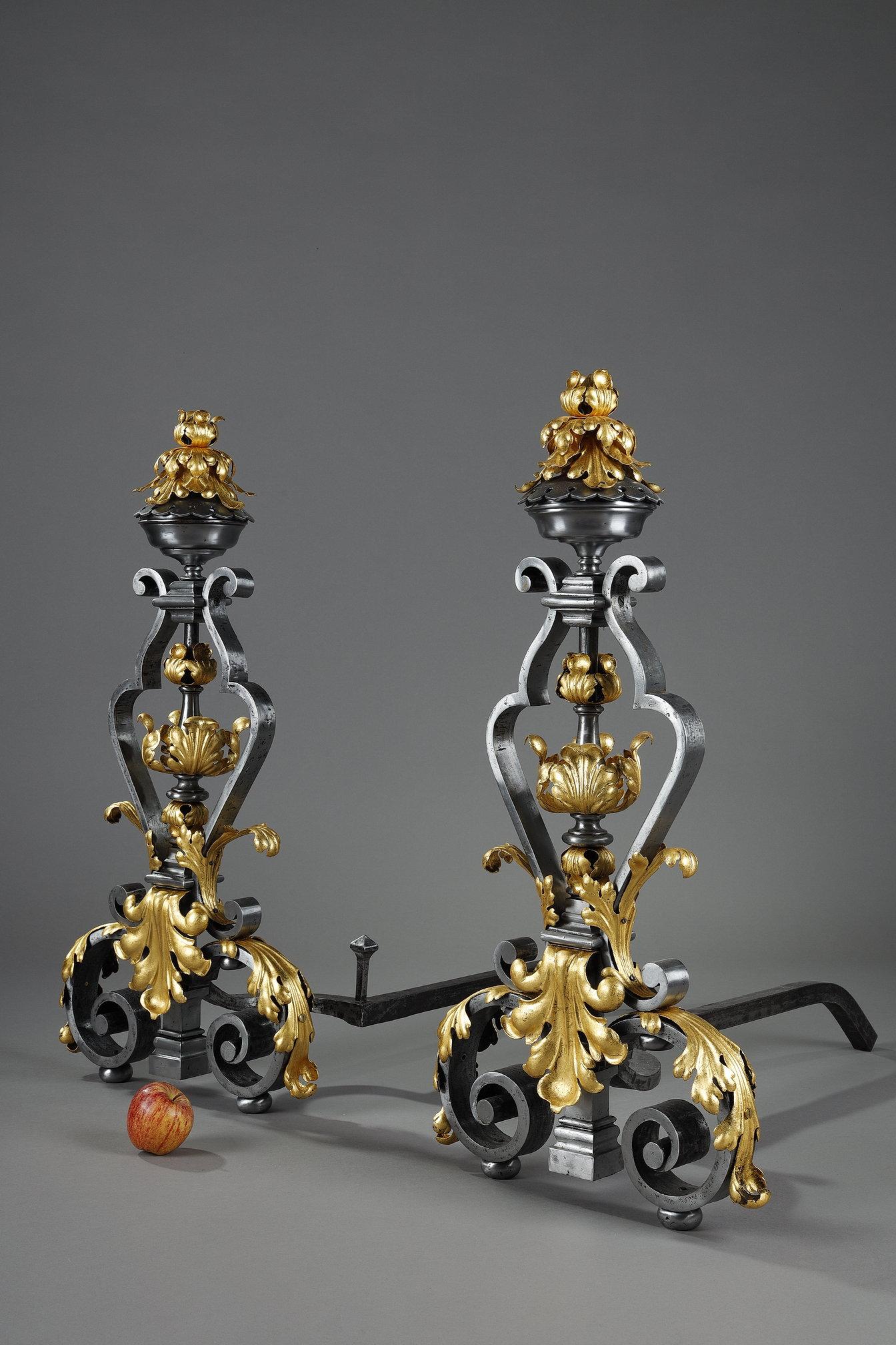 Una bella e grande coppia di caminetti in ferro battuto decorati con volute e fogliame impreziositi da foglia d'oro. I colori contrastanti sottolineano il carattere decorativo degli androni. Vengono forniti con il loro ferro per contenere i tronchi.