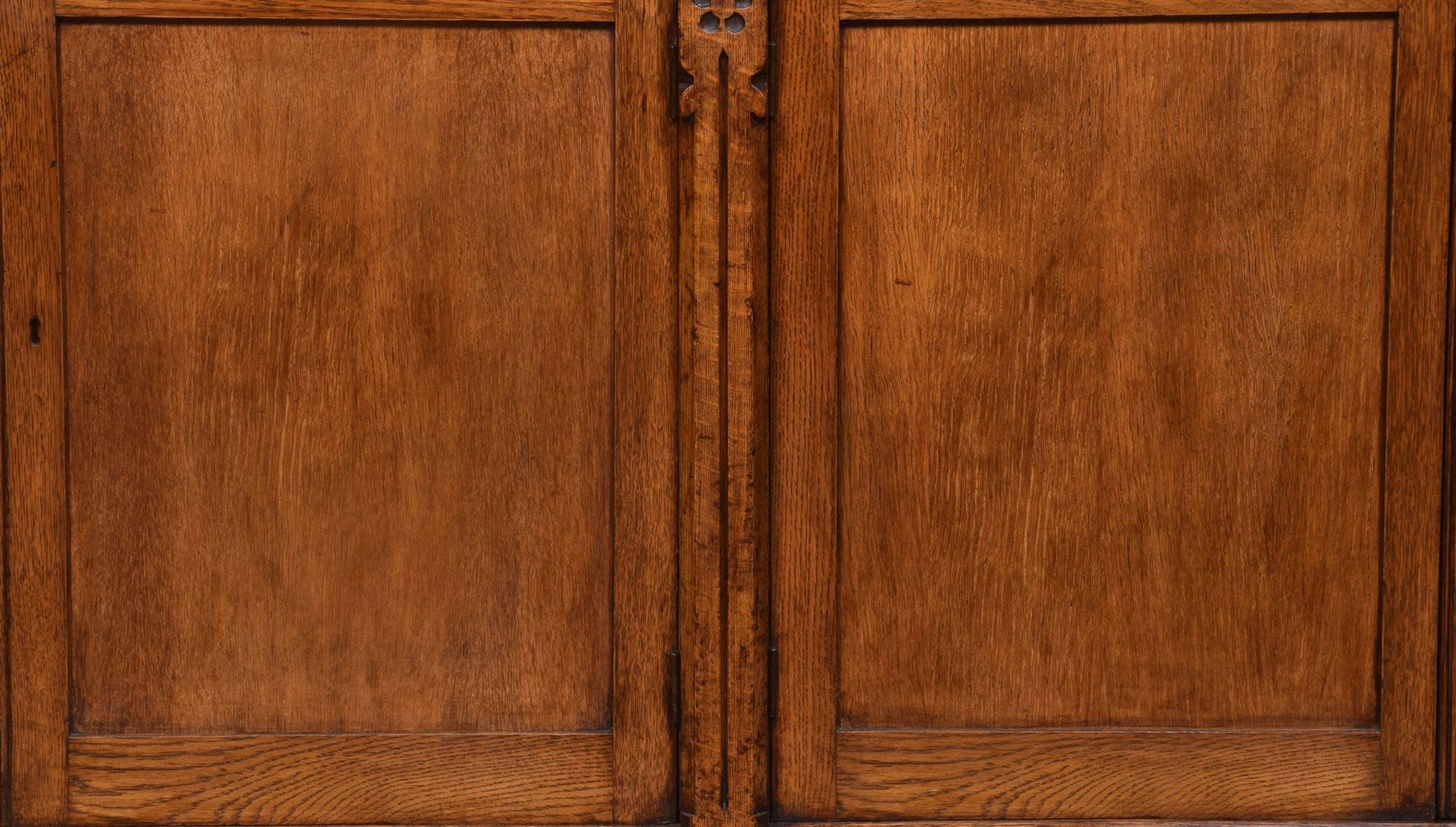 19th century oak bookcase with a flared cornice over two large bays of adjustable shelves. The base section fitted with four panelled doors enclosing a shelved interior. All raised up on plinth base.
Dimensions:
Height 97 inches
Width 88