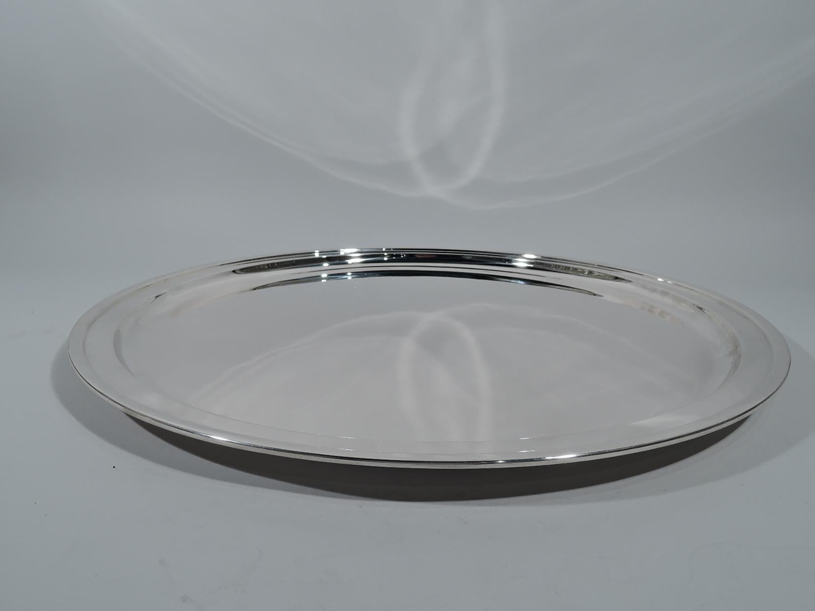 Very large sterling silver serving tray. Made by Tiffany & Co. in New York. Circular with molded rim. The traditional form super-sized. Hallmark includes postwar pattern no. 23542. Weight: 106 troy ounces.