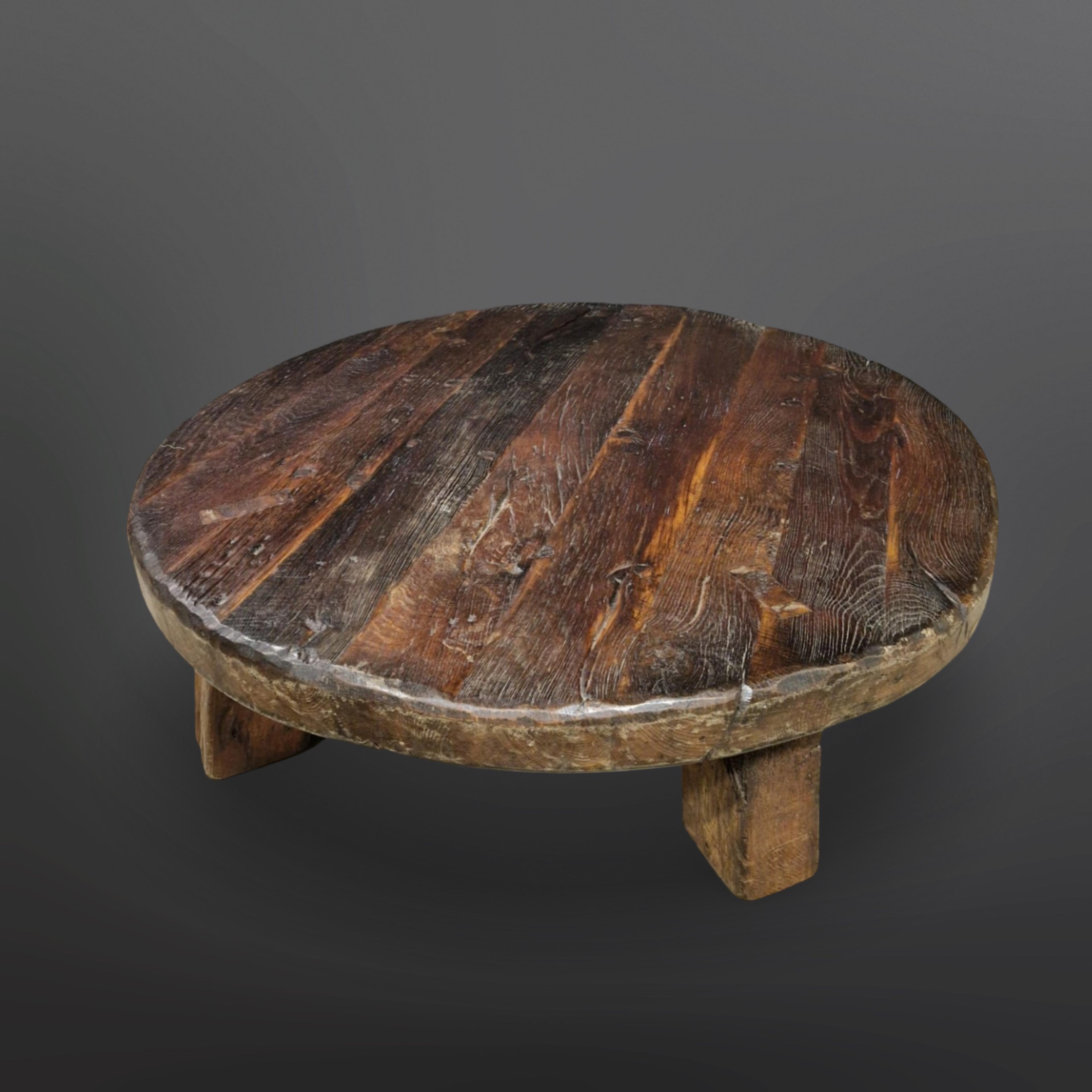 Hand crafted solid oak coffee table. 130cm thick round top with lots of patina and relief. The four legs have been mounted through the top showing the end wood and the wedges they are secured with. It was made in Europe. Probably in the Netherlands,
