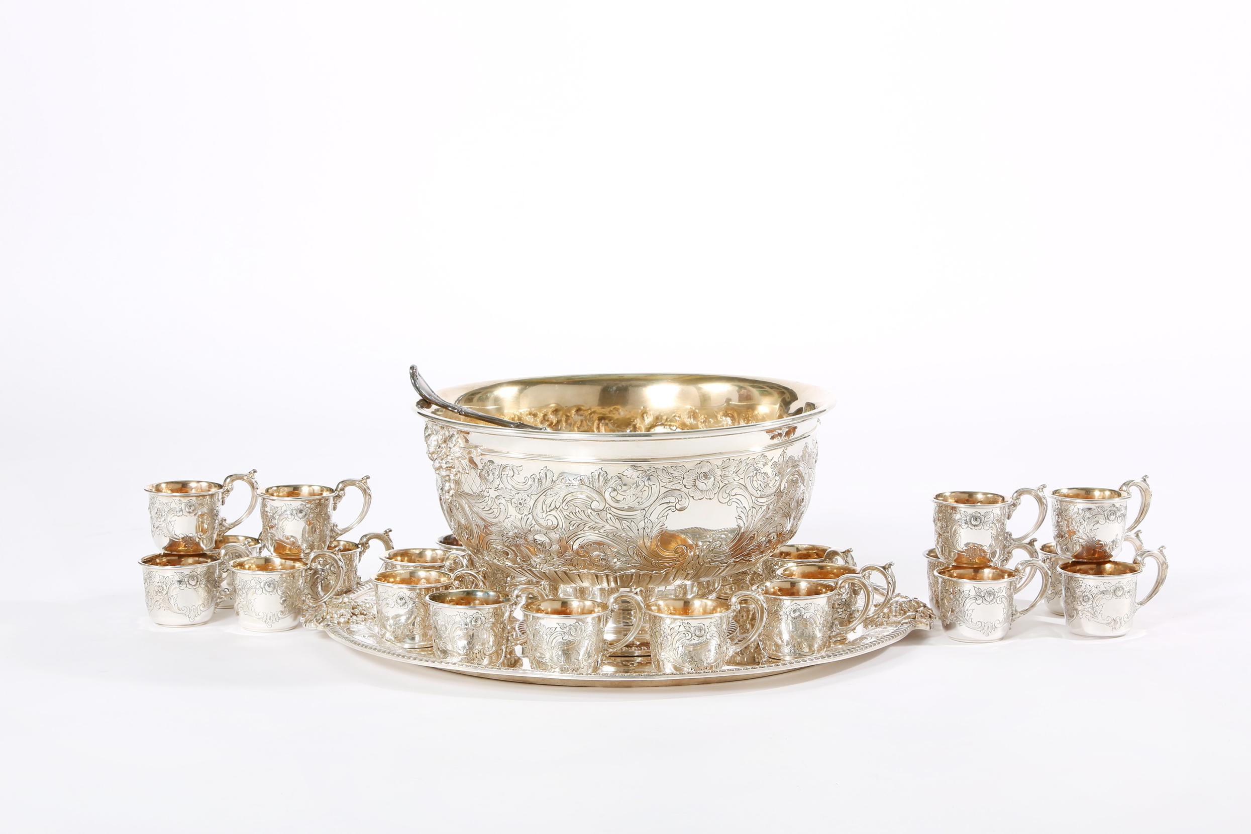 Very large and ornate design details North American regent style silver plated with gold wash interior punch bowl service for 24 people. Good condition. Minor wear consistent with age / use. Maker's mark undersigned. All together twenty seven piece.