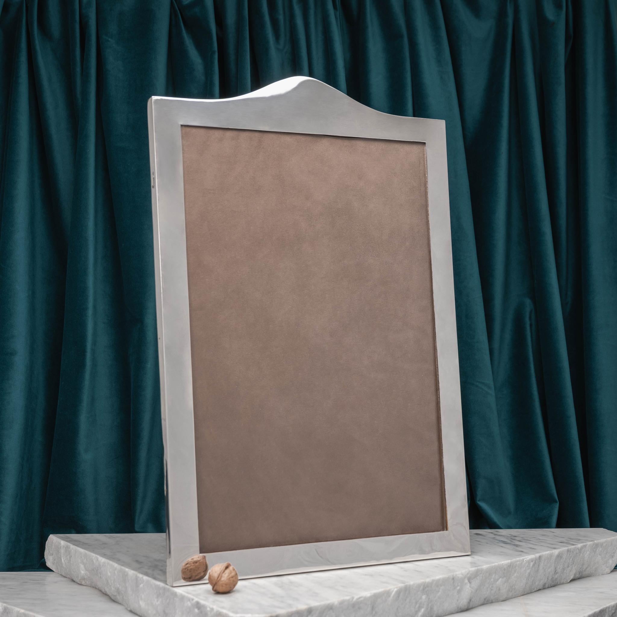 A magnificent silver Queen Anne style arch topped picture frame, hallmarked London 1902, with original oak back and foot. Maker's mark for Goldsmiths and Silversmiths Co.

Dimensions: (Frame) 58 cm/22⅞ inches (max. height) x 38 cm/15 inches (width)