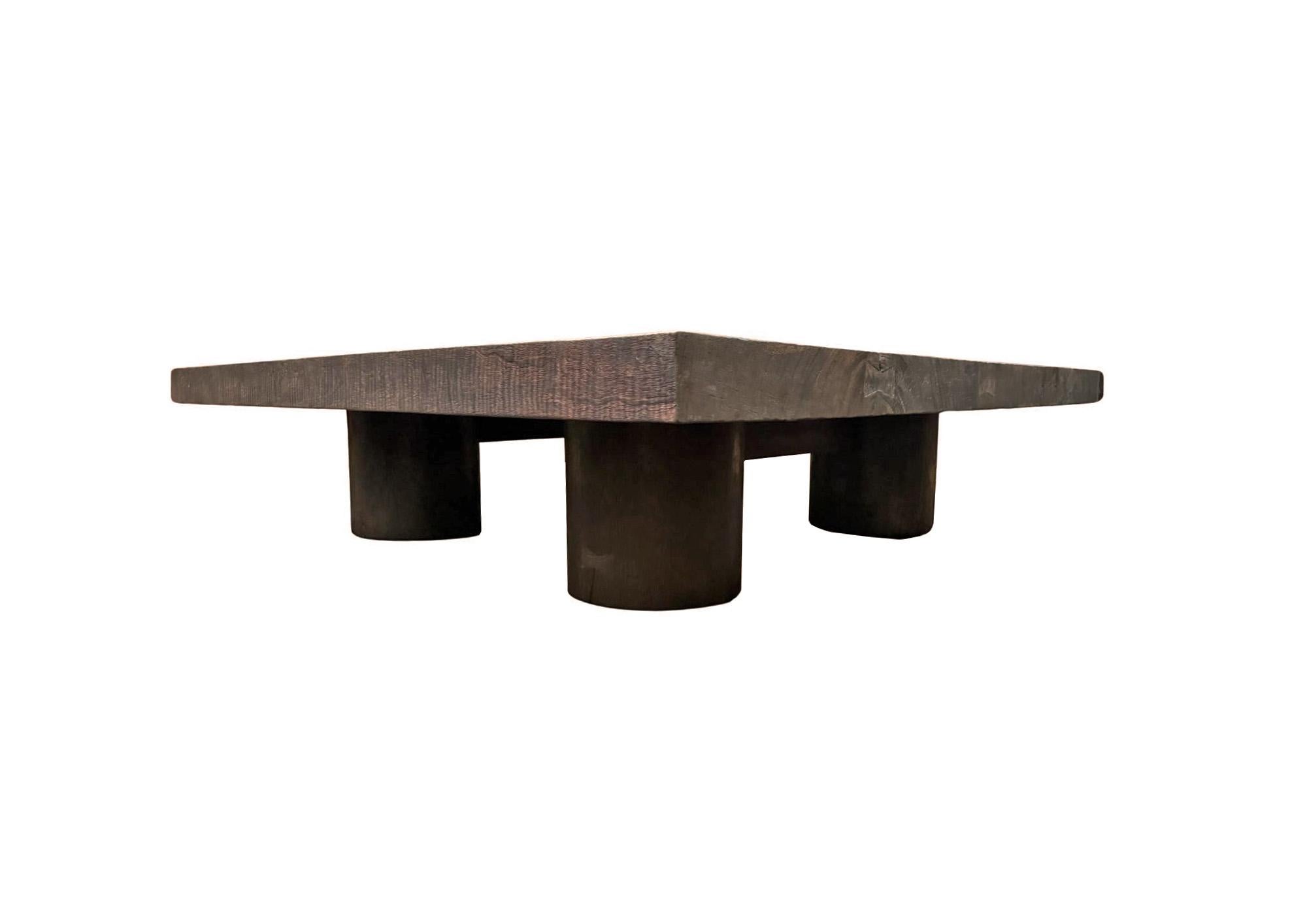Crafted from solid suar wood, this striking coffee table features a bold, minimalist design that emphasizes natural beauty and structural strength. The square tabletop showcases the rich, organic grain patterns of suar wood, finished in a deep