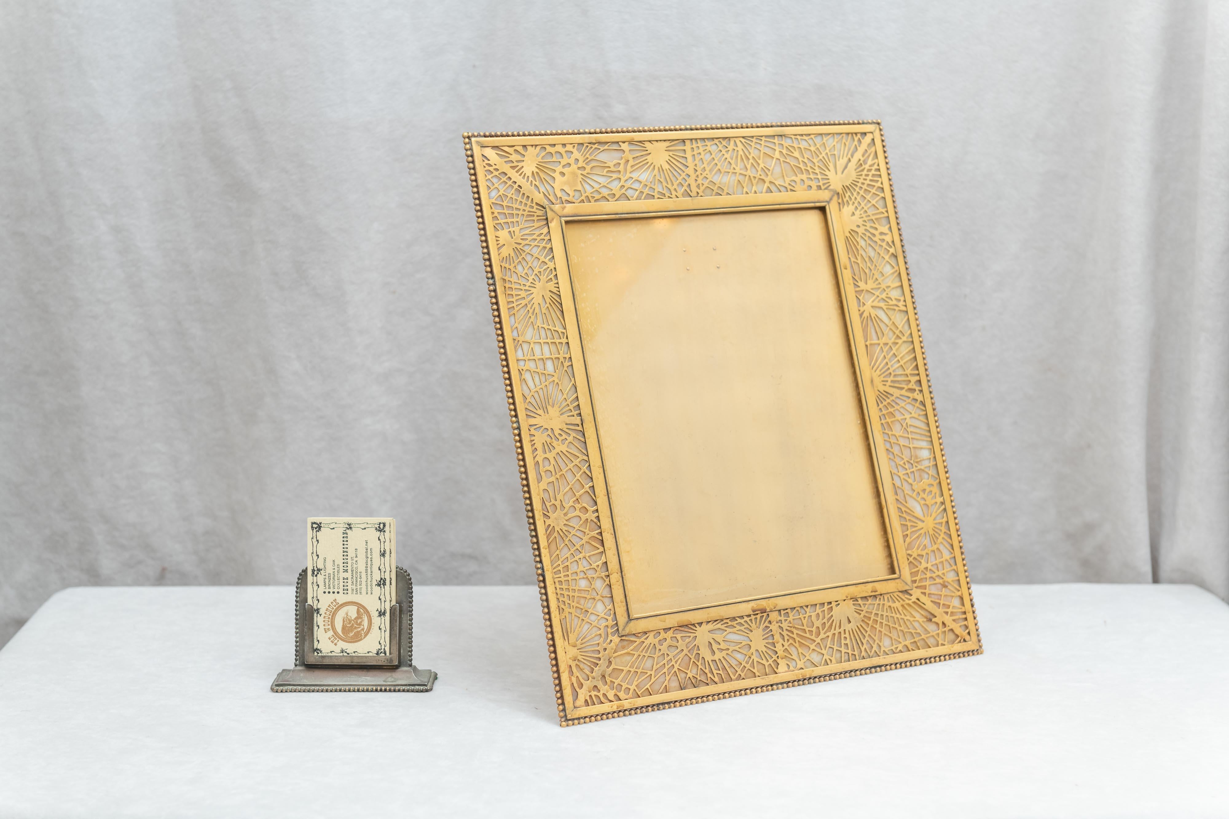 This is the same Tiffany Studios who made all those wonderful lamps. Among other items they are picture frames. Many of the more desirable ones had glass around the border as is the case here. This is about as large a picture frame as Tiffany made.