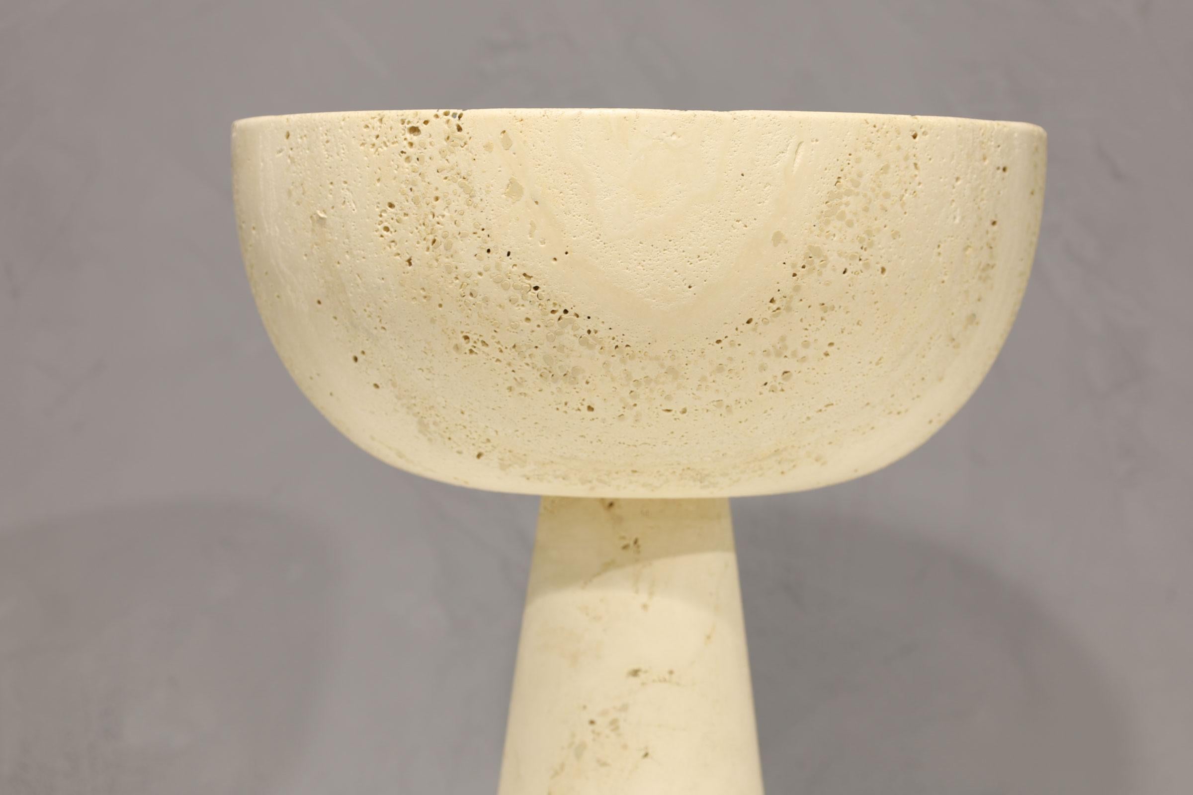 This bowl is very heavy and appears to be made from a solid piece of travertine. It has a mate which you can see in our listings. They are quite beautiful together and very well crafted.