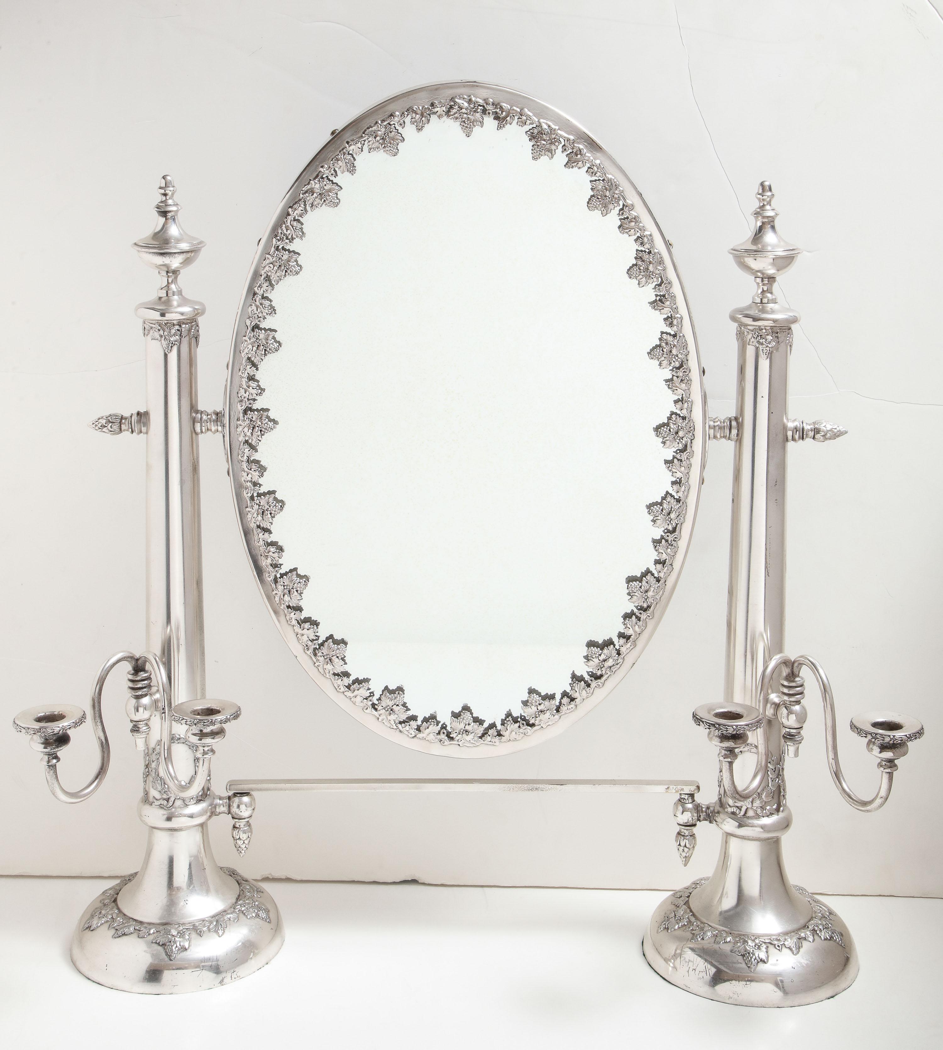 Very large, Victorian, Sheffield silver plated table mirror, Lawrence B. Smith Co., Boston, circa 1895. Measures: 26 inches high (at highest point) x 25 inches wide (from candleholder to candleholder) x 6 1/2 inches deep. Mirror itself, which