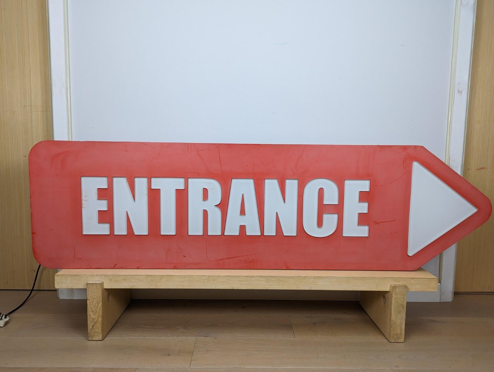 A very large vintage 'Entrance' advertising sign.

The box is made from metal which has been painted red. The sign lights up and has been converted to a 3 pin plug.

 There is some natural fading to the colour of this item as it has been used