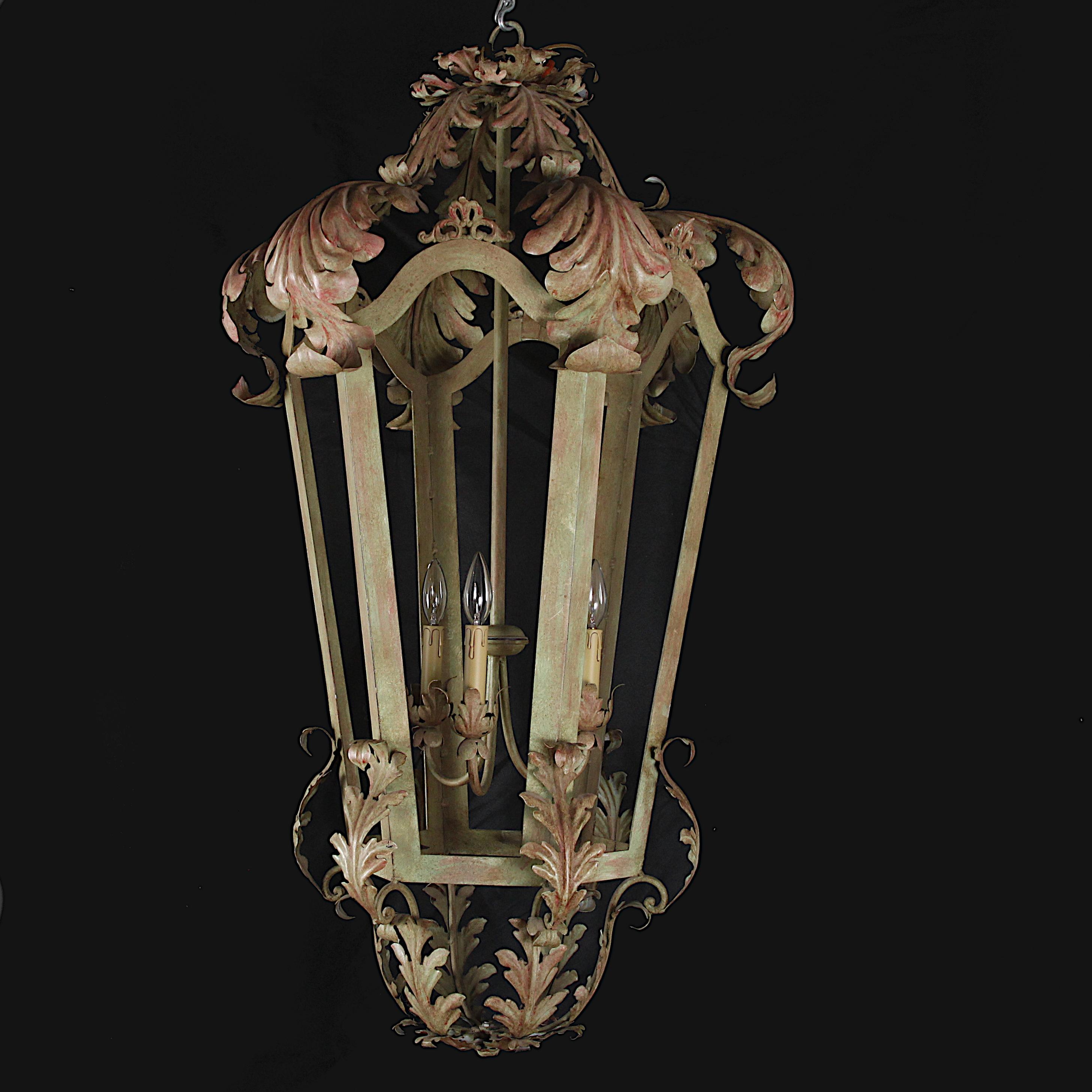 An oversized French vintage hanging three-light lantern, of an open-framed tapering hexagonal form with leafy foliage details to top and bottom.