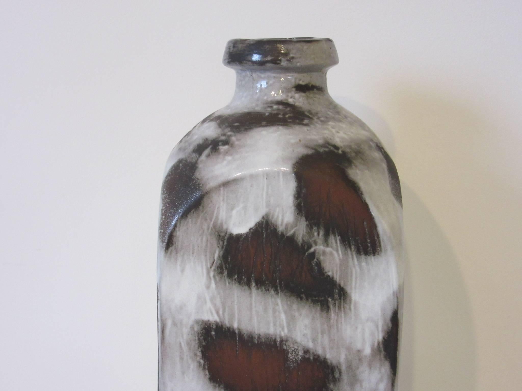 A very large sized pottery vase with free-form glazing in cream, dark browns and black signed to the base and numbered Mendoza with a small tag made in Germany by The Hanns Welling Ceramano Company.