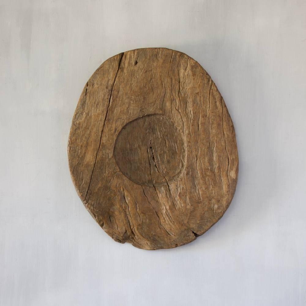 A very large wooden plate, hewn from a single piece of hardwood and with a wide adzed finish. Age and origin unknown.
