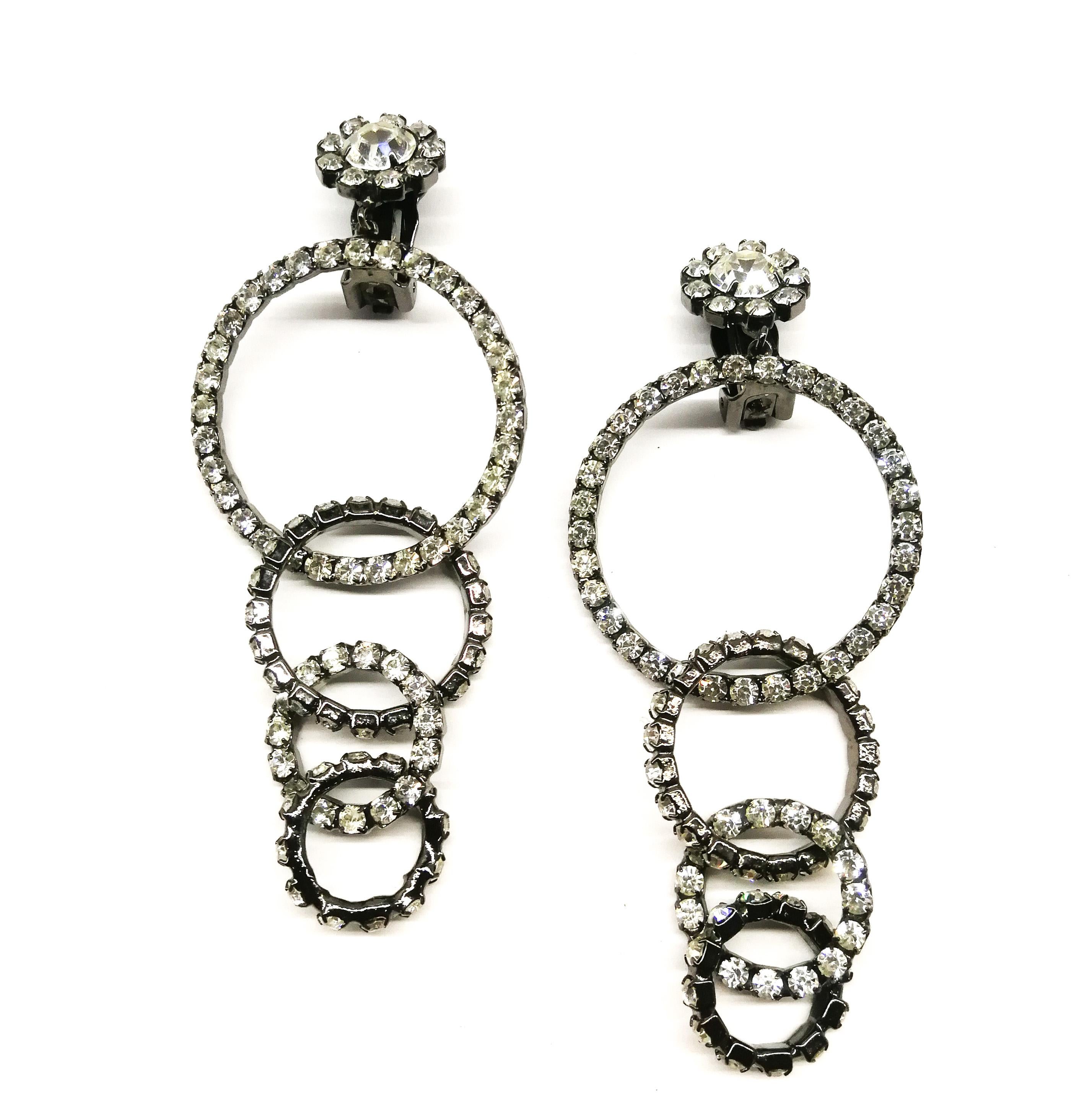 Striking and shoulder dusting interlocking hoop drop earrings, from a later Kenneth Jay Lane, of lovely quality and design, clear pastes set in a darkened grey metal. Both earrings are signed and are the perfect Seasonal gift or classic earrings for