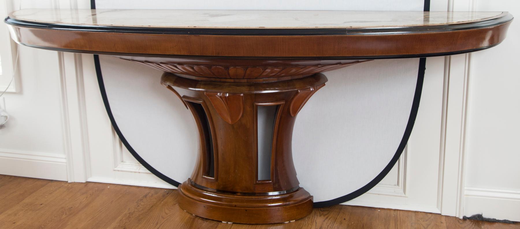 Wonderful and long demilune-shaped console table with an inset marble top resting on a pedestal base in solid walnut with stunning leaf carvings.  The base is  in solid walnut and is shown with  its original and breathtaking  marble top in beige
