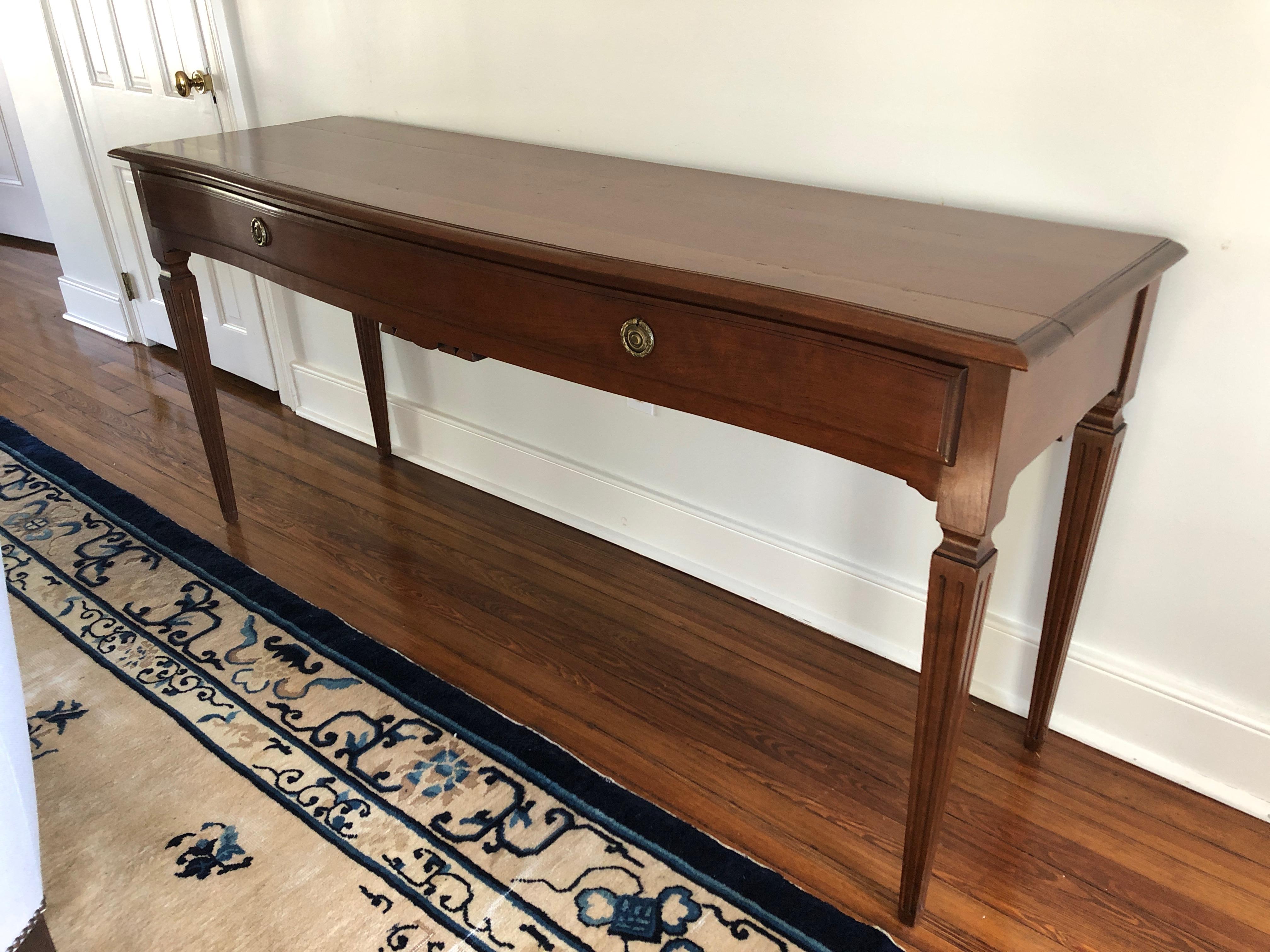 Elegant mahogany very long console or sideboard having one elongated drawer with original brass hardware and lovely tapered reeded legs.
