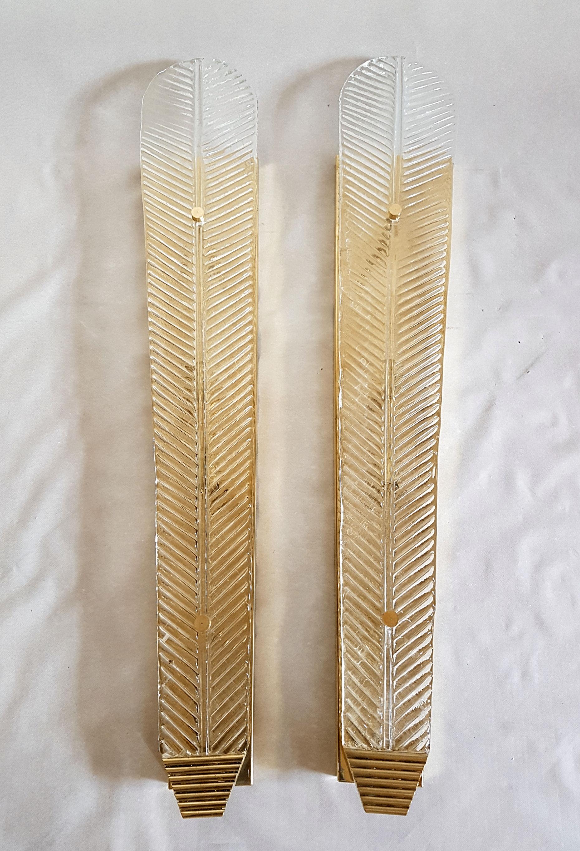 Very tall, long and thin pair of wall sconces, by Barovier & Toso, Italy, 1960s.
Made of polished brass mounts, and hand made Murano clear glass leaves.
The veins of the glass leaves make them translucent.
2 lights, medium base, rewired for the