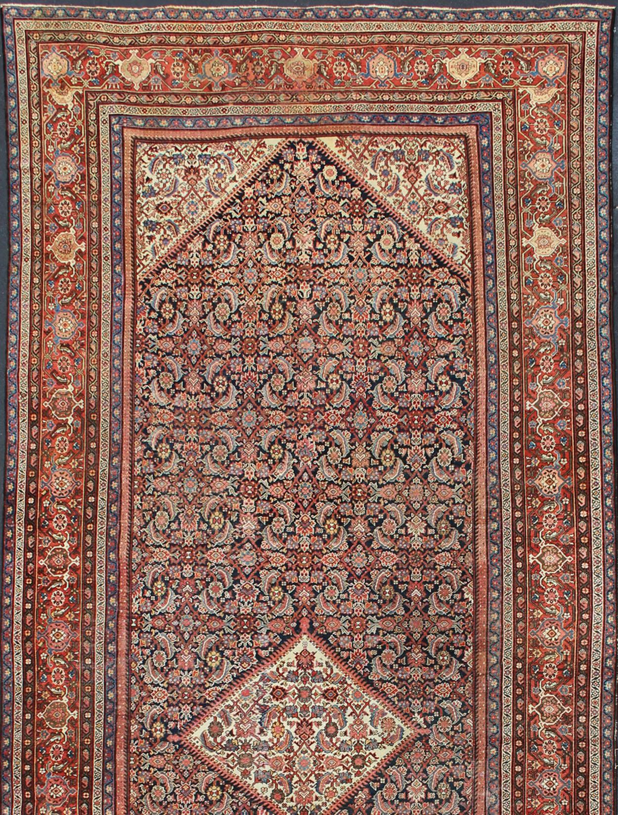 Very long Persian Sultanabad rug with Herati Design in dark blue and red.
This antique Sultanabad rug was woven in Persia during the latter years of the 19th century. Persian Sultanabad rugs are admired for their exceptional compositions, which
