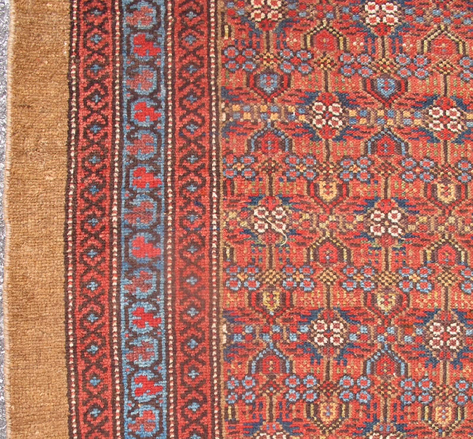 Long runner antique rug from Persia with simple geometric design in camel, tan, red, blue tones, rug 13-0516, country of origin / type: Iran / camel hair, circa 1900.

This handwoven, antique Persian camel hair Serab rug features a small repeating