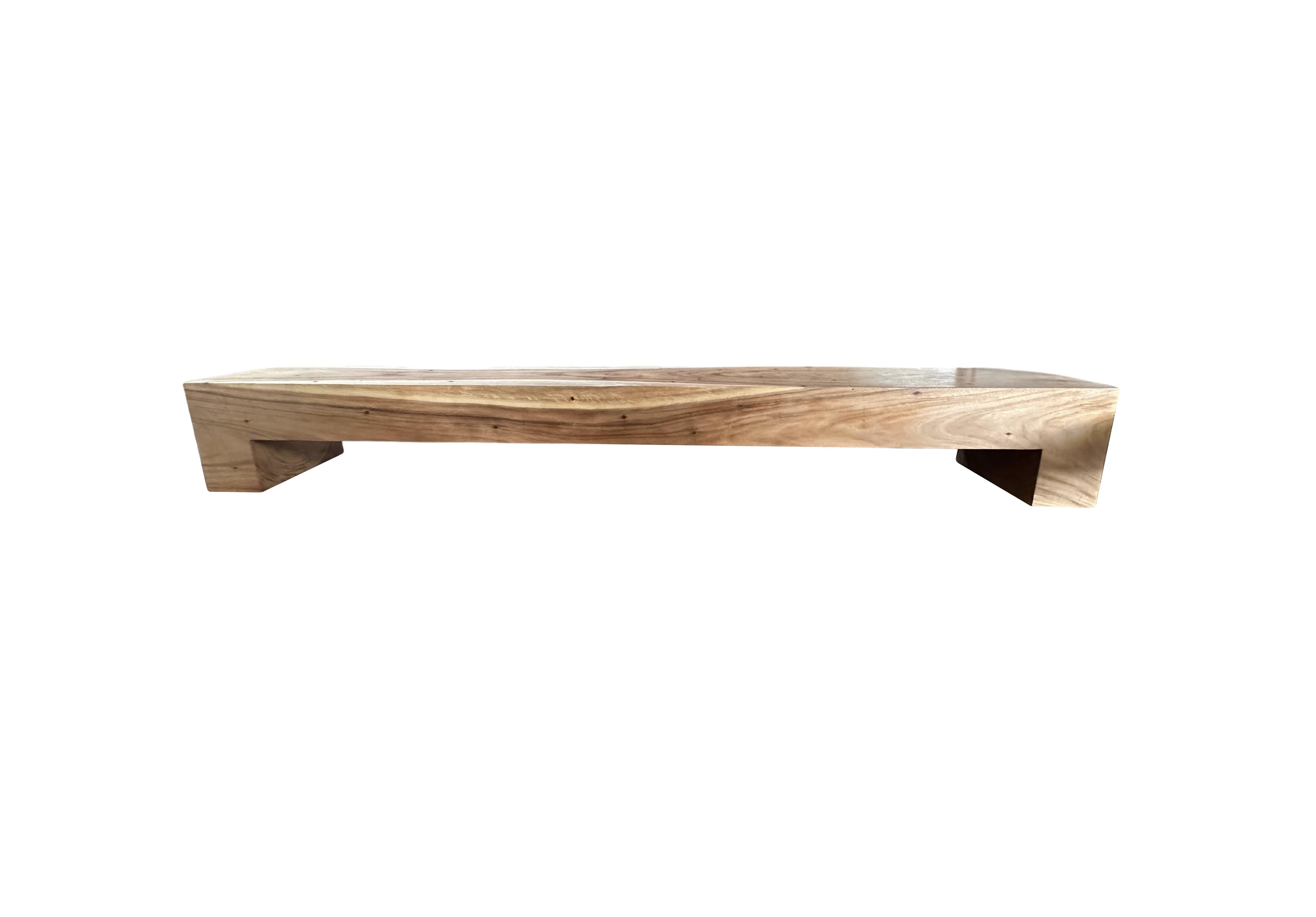 A sculptural suar wood bench carved from a single trunk. The bench is very wide at 118.11