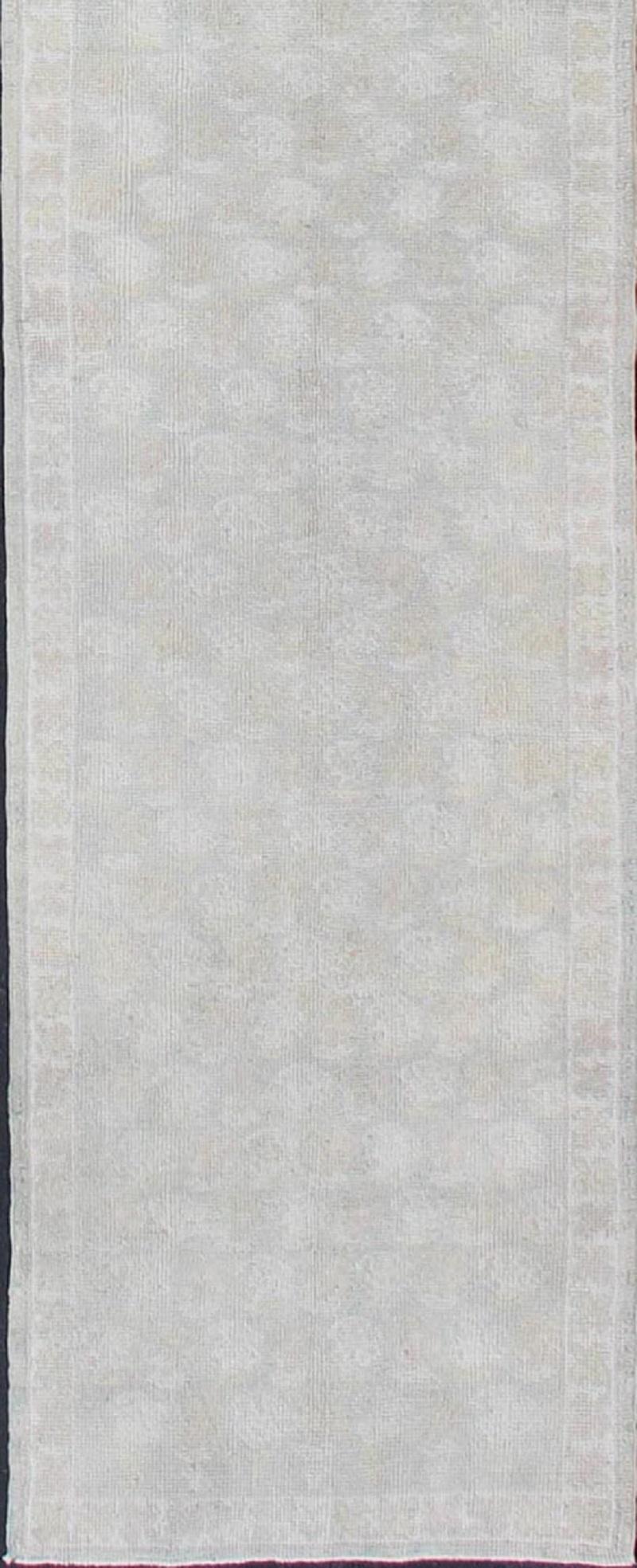 This unique Turkish Oushak carpet features an all-over design of intricate paisley shapes set atop a central field of light tones. The entire piece is encompassed by a floral border. Accent colors are rendered in muted tones.

Measures: 3'3'' x