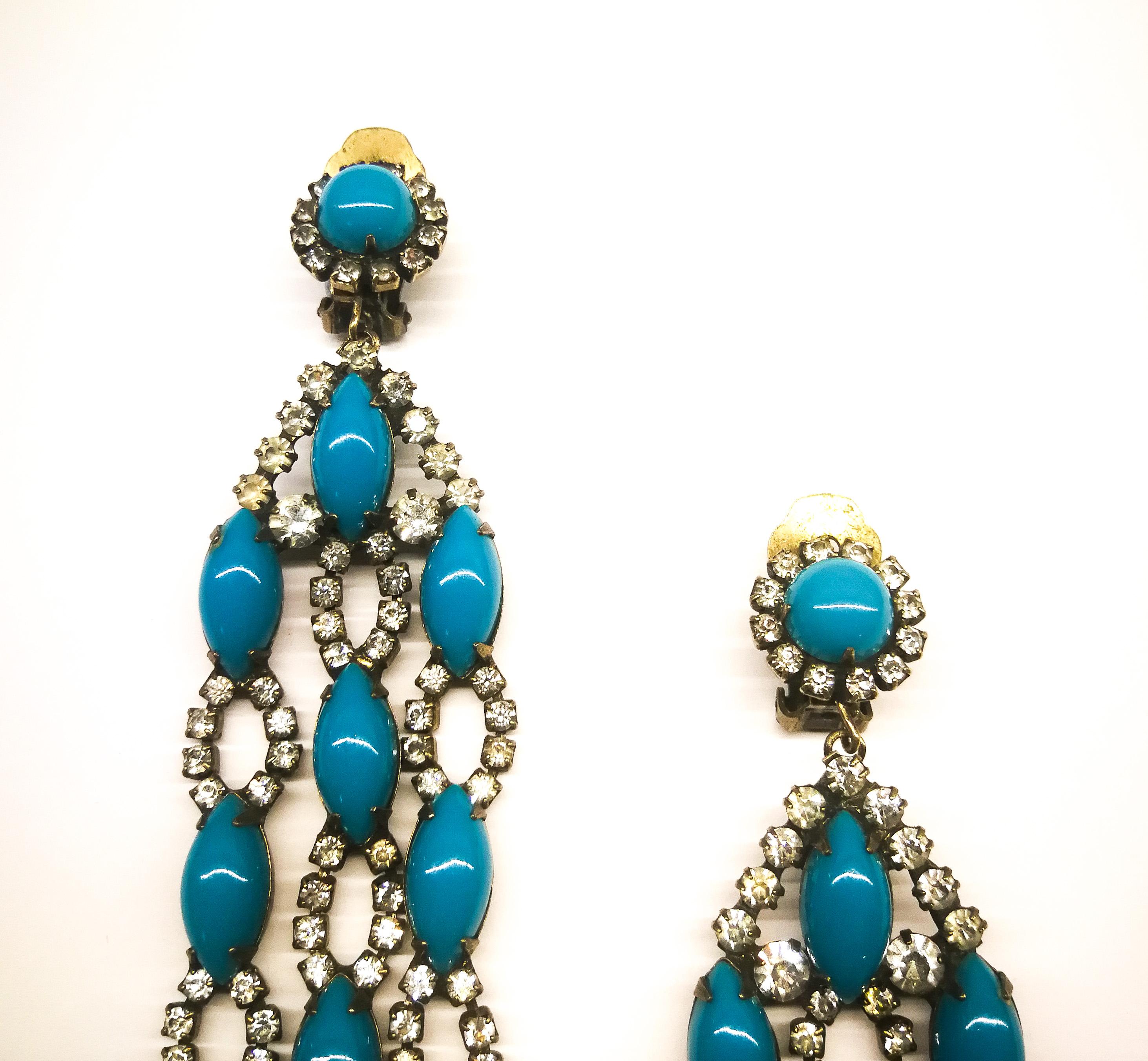 Spectacular and very glamorous three row drop earrings, with three articulated drop row of alternating turquoise glass cabuchons and clear pastes, made by Kenneth Jay Lane. These are a piece of 1960s glamour, chic and iconic, the earliest creations
