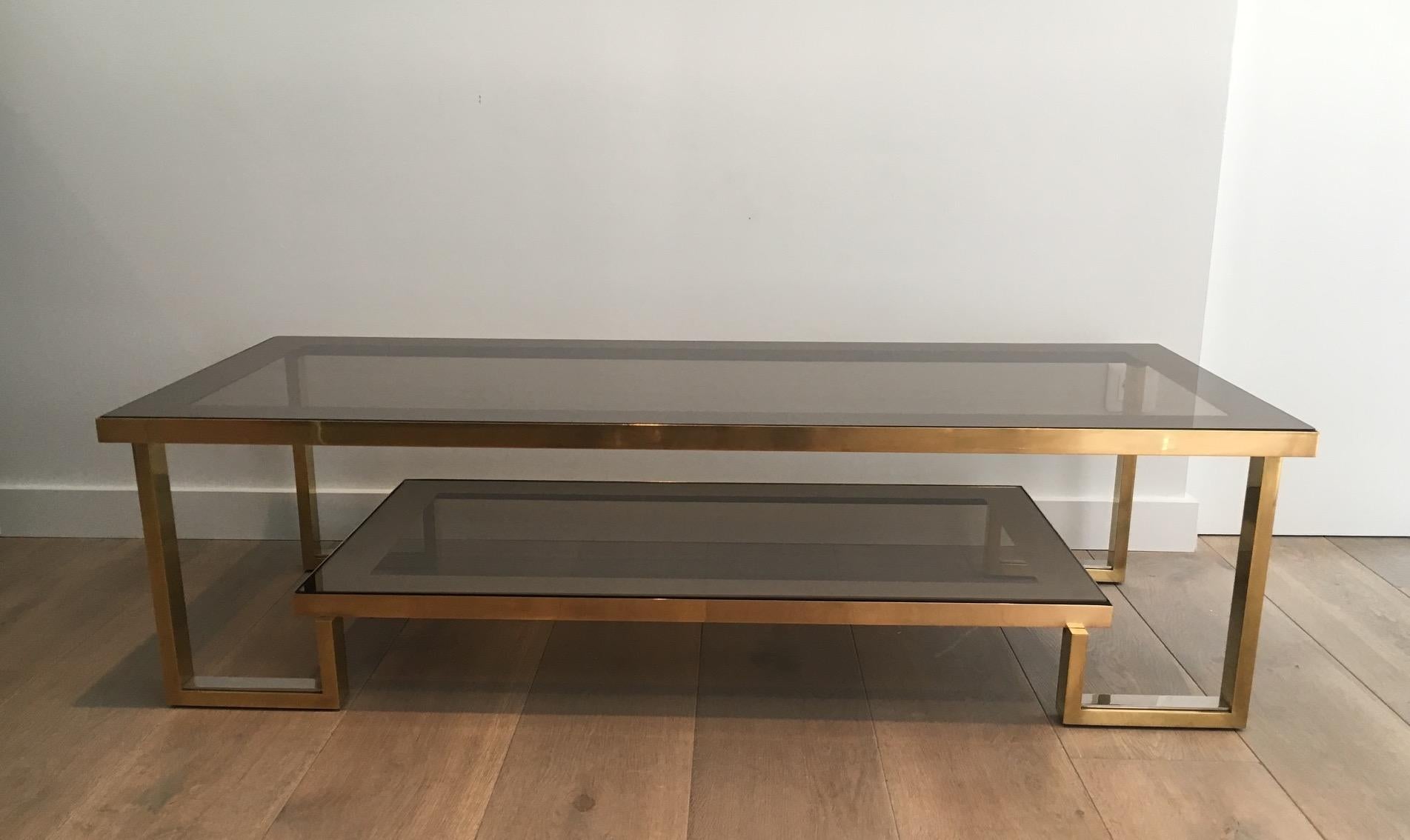 This very nice coffee table has a base made of brass and chrome with 2 smoked glass shelves surrounded with a bronze mirror. This is an interesting French work, in the style of Willy Rizzo, circa 1970.
