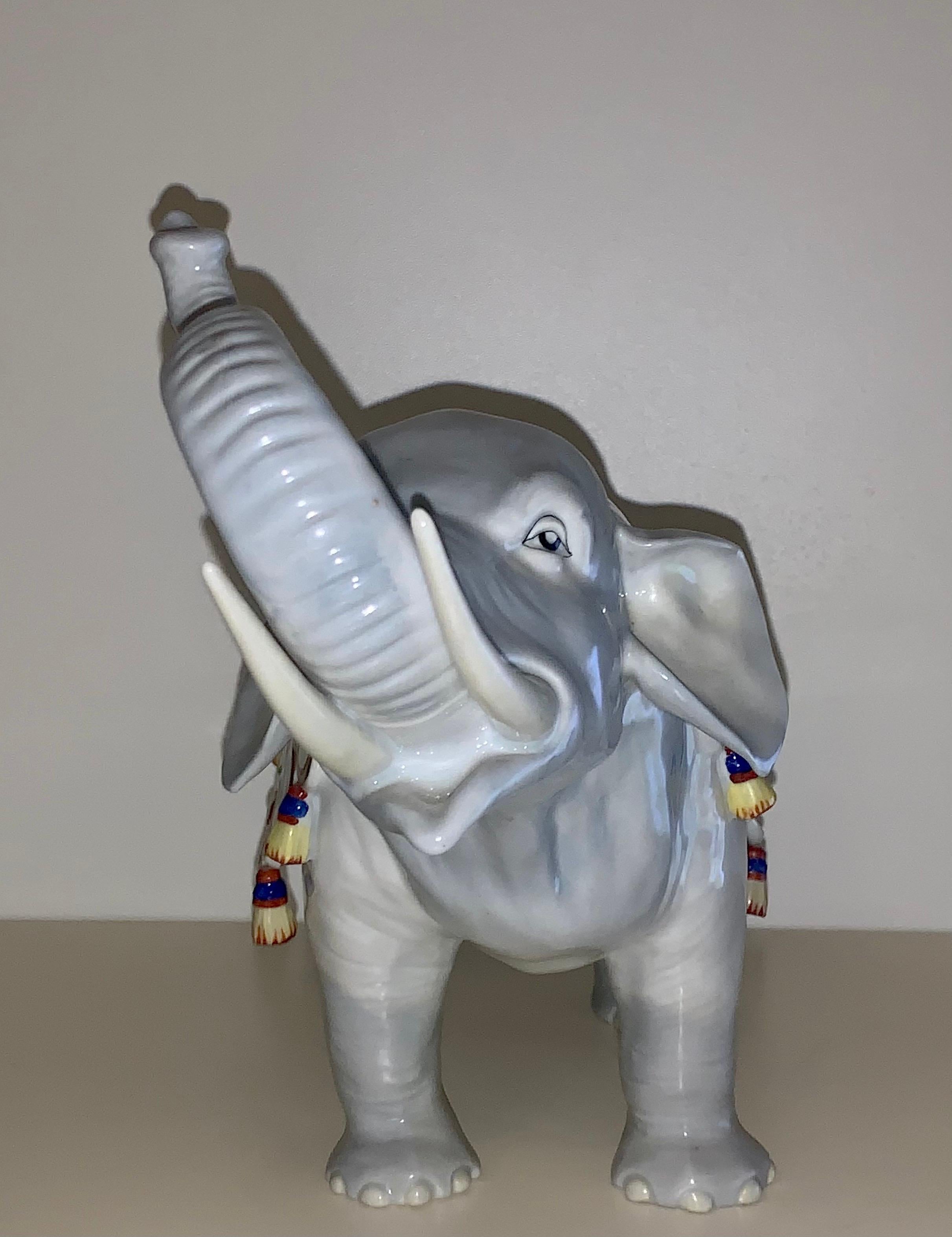The elephant is shown with its trunk raised and is draped with an embroidered and tasselled blanket. Hand painted and modeled with fine detail. Carl Thieme founded his porcelain factory in Potschappel, Germany in 1872. Once a decorator and porcelain