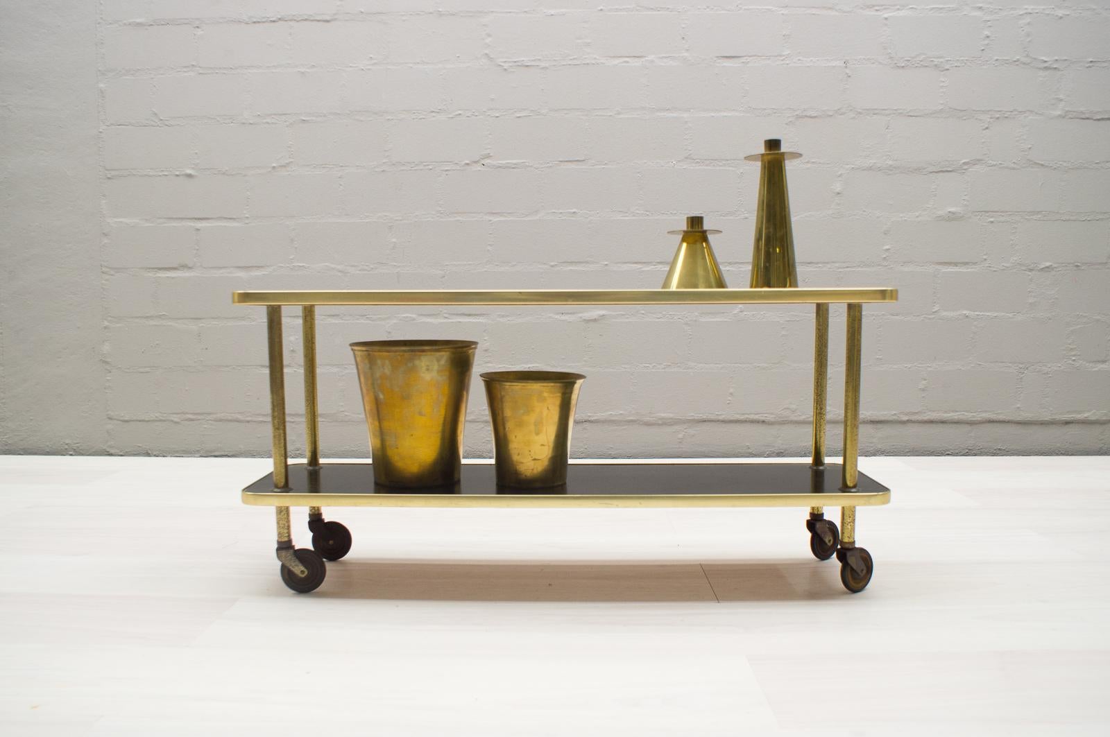 This trolley has a very rare form. 

It is slim and elegant and usable as serving trolley as well as a storage shelf.

The brass has a typical patina, see pictures.
