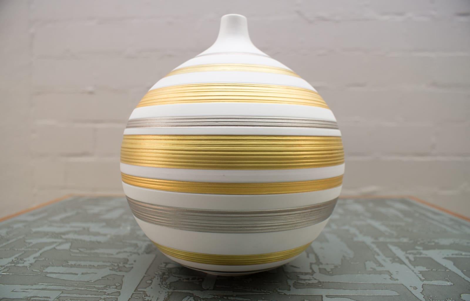 Very noble and elegant vase in a beautiful size from the traditional porcelain manufactory Hutschenreuther, Germany. 

White bisque porcelain wonderfully framed in gold and silver. 

Hans Achtziger (1918 - 2003, Germany), important modeller for