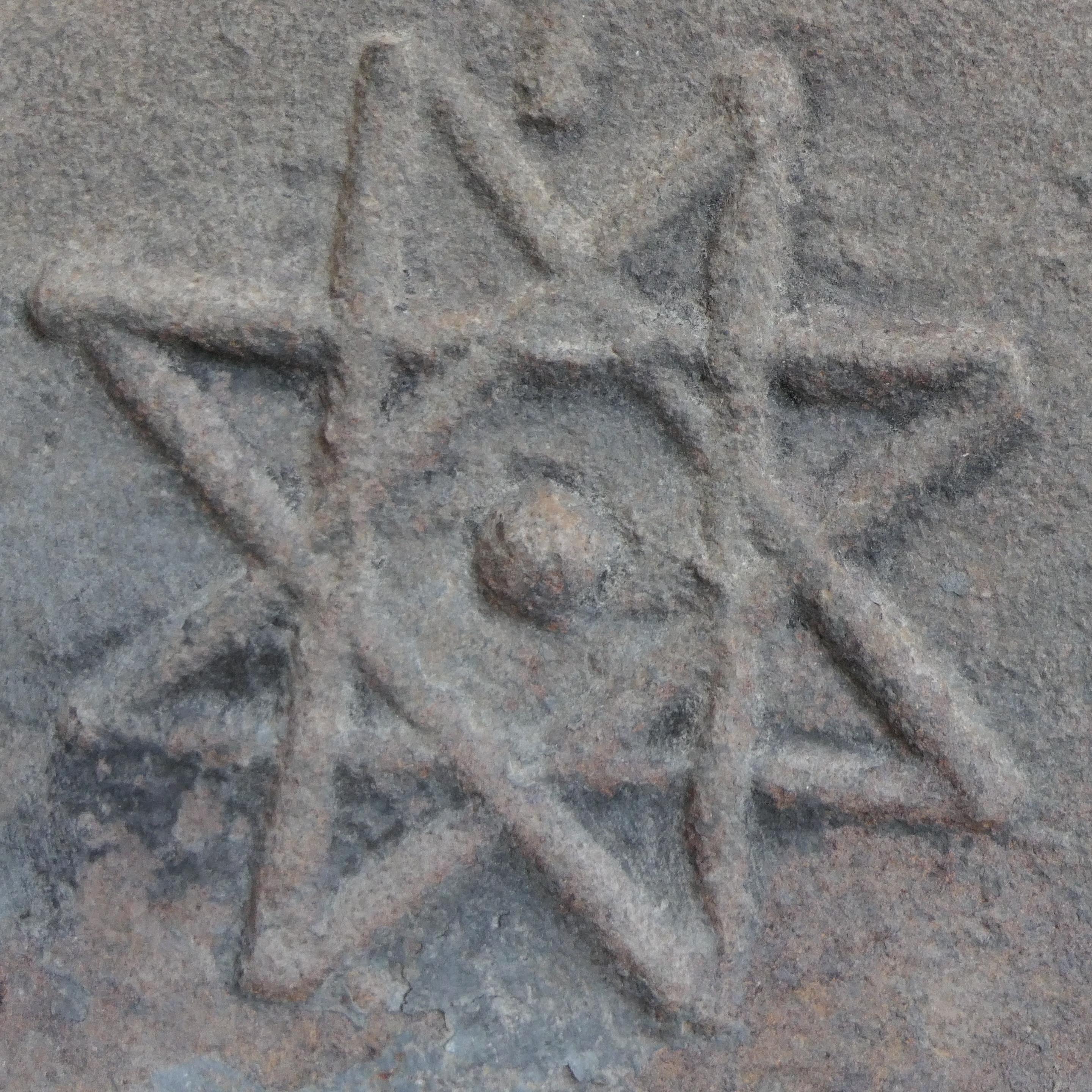 Very old cast-iron fireback. 
Dimensions (width x height x thickness): 87 x 76 x 4 cm
Represented by a cross reminiscent of the Christian cross and an 8-pointed star.
